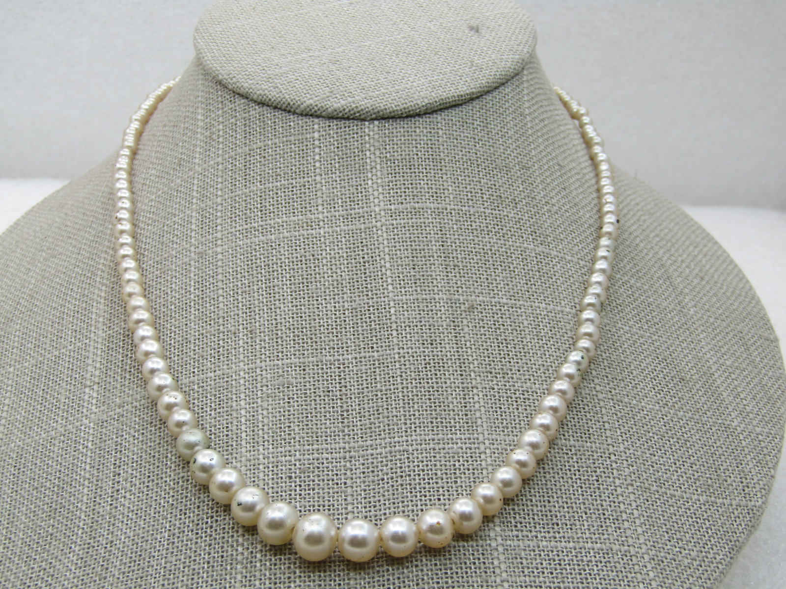 Vintage Graduated Faux Pearl Necklace, 17.5", 2.5mm-7.5mm: Vintage Graduated Faux Pearl Necklace, 17.5", 2.5mm-7.5mm, light cream colored with a 10mm round faux pearl button box clasp. Silver tone box part of the clasp does have finish roughness on part of it