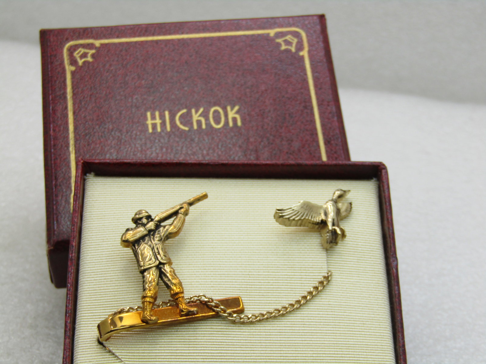 Vintage Gold Tone Hickok Duck Hunter and Duck Tie Clasp and Tack Pin, Original Box: Vintage Gold Tone Hickok Duck Hunter & Duck Tie Clasp & Tack Pin, 1960'S, Original Box with enclosure card. Mid-Century. New Condition. 1.25" wide and tall on the hunter with chain and 1" duck. Very g