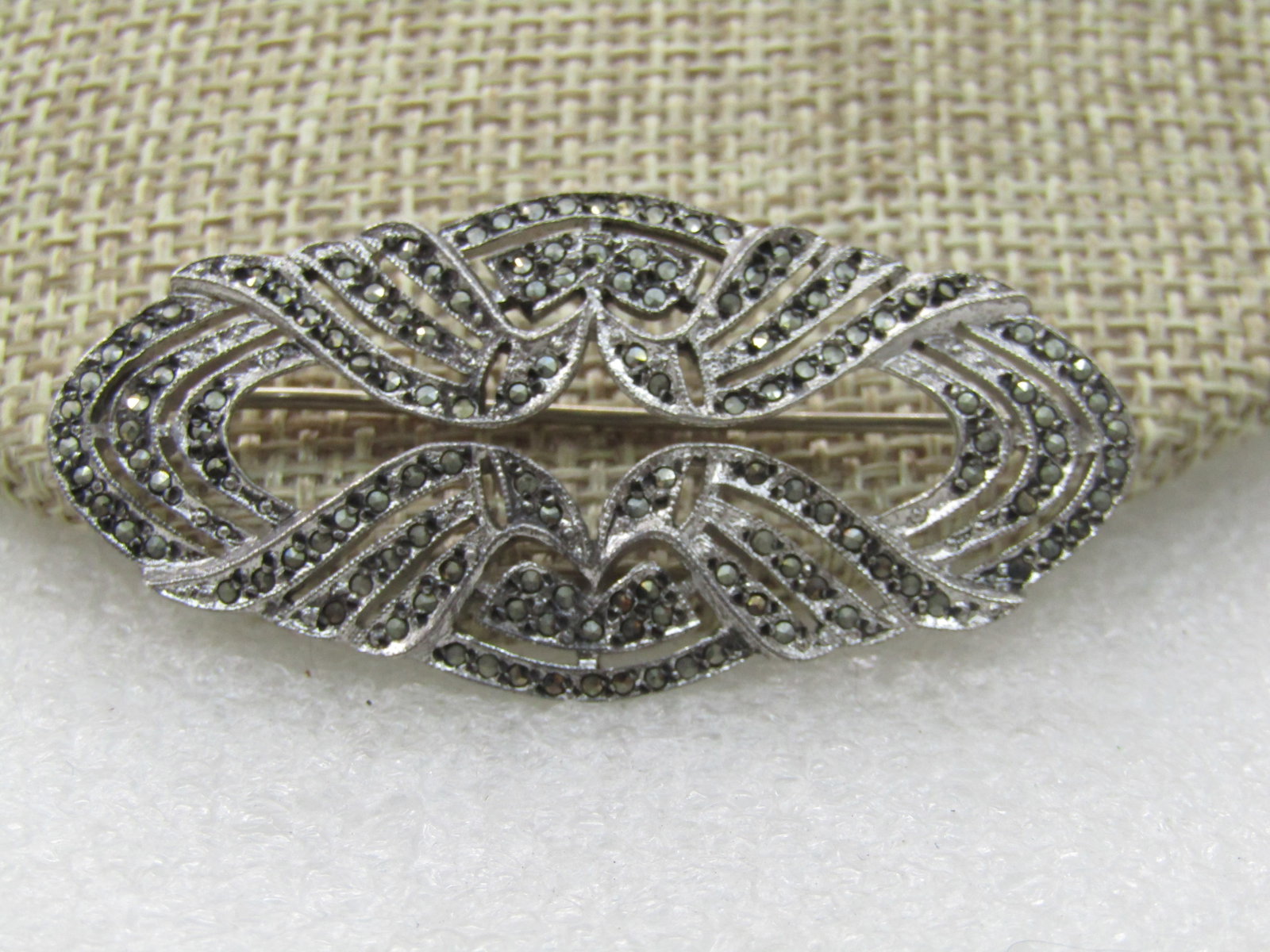Vintage Sterling Marcasite Open Brooch, 2": Vintage Sterling Marcasite Open Brooch, 2" by 1". Mid-century. Oval-ish frame with open work in the center and a triple band design with small marcasites set throughout. Marked sterling and tested. No
