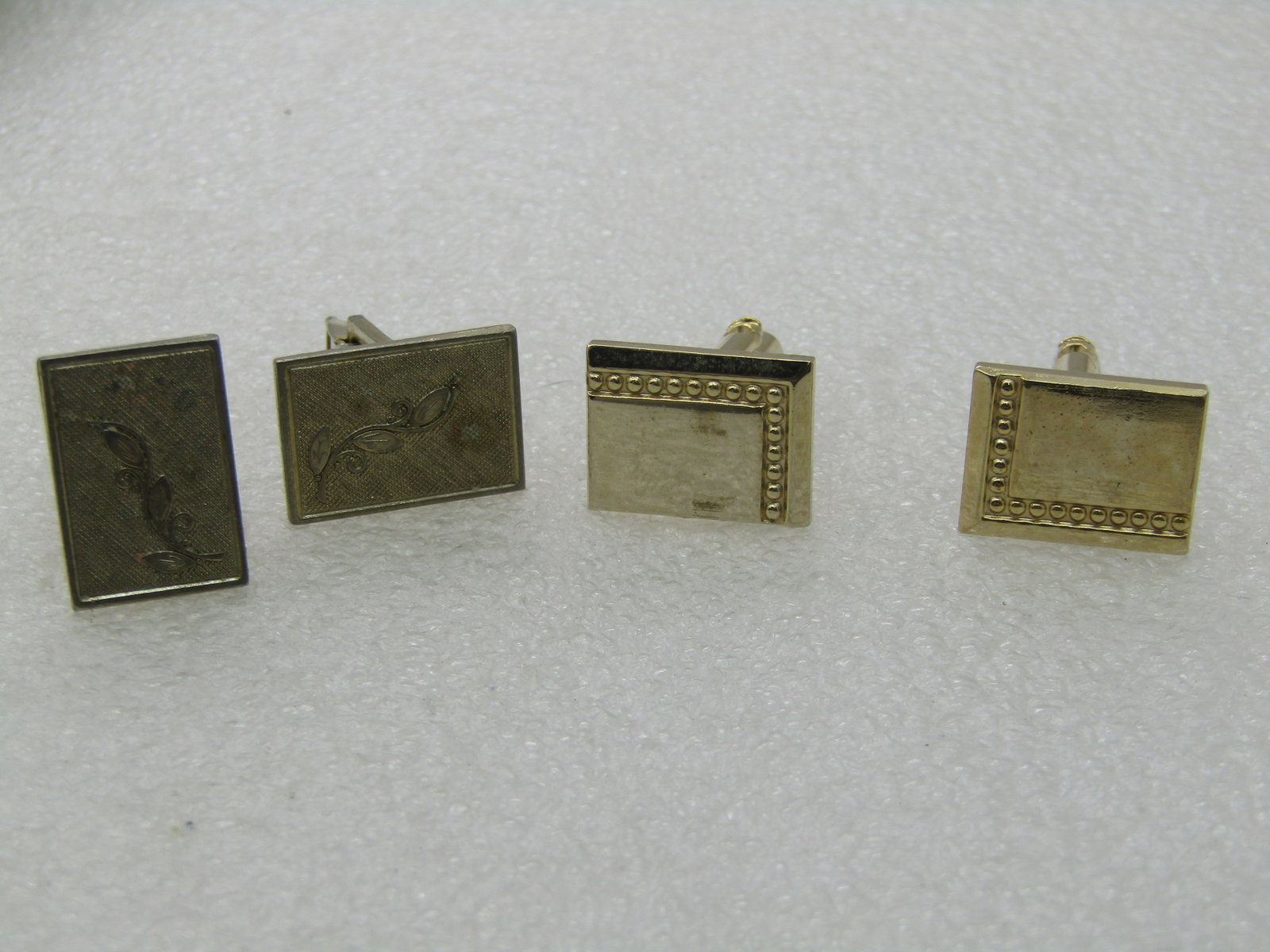 Vintage 2 Pair Cuff Links, Gold Tone, Art Deco Themed: Vintage 2 Pair Cuff Links, Gold Tone, Art Deco Themed. Rectangular and each appx. 3/4" by 1/2", one with a shiny finish and the other set with a textured finish and each have an art deco design to the