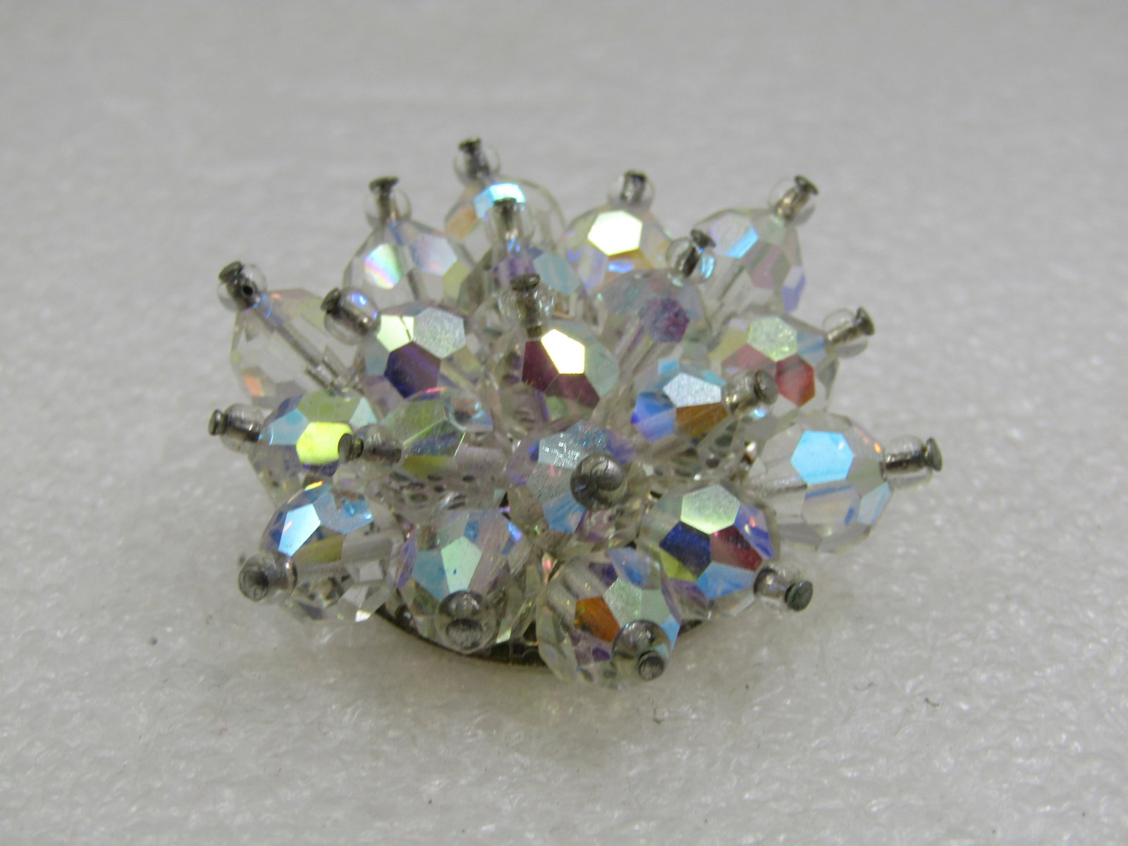 Vintage Aurora Borealis Crystal Brooch, 1960's: Vintage Aurora Borealis Crystal Brooch, 1960's, 1.75" across, blossom/snowflake design with the beads arranged outward. Sivler tone setting. Not signed by the maker, very good condition. (W.91920.6 SS