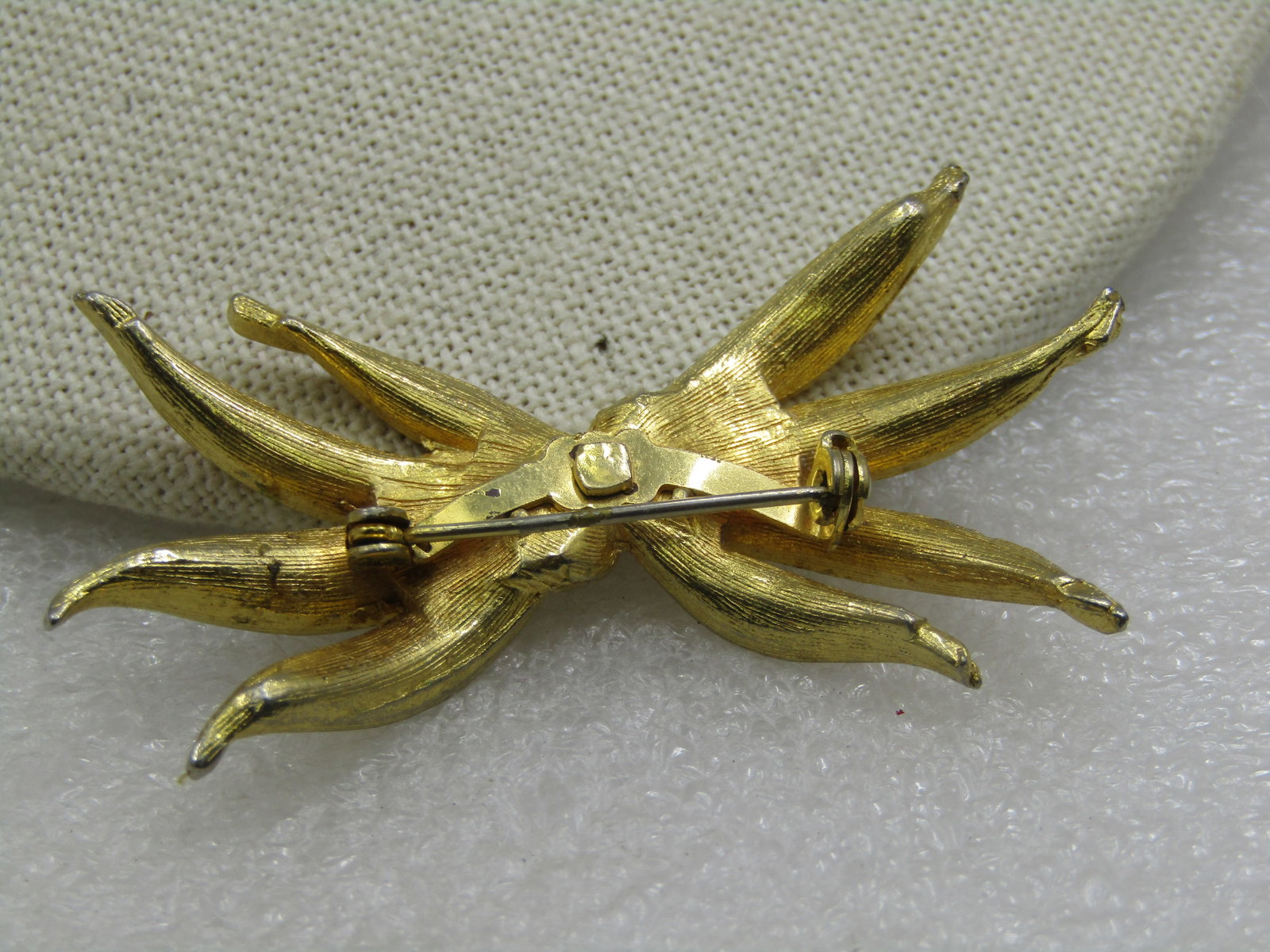 Vintage Gold Tone Leaf Swag Brooch, 1960's, 2.5": Vintage Gold Tone Leaf Swag Brooch, 1960's, 2.5" wide and 1.25" tall. Four long curved textured leaf blades with a center diagonal band, not signed by the mkaer. Very good condition. (W9.19.20.6 SS668