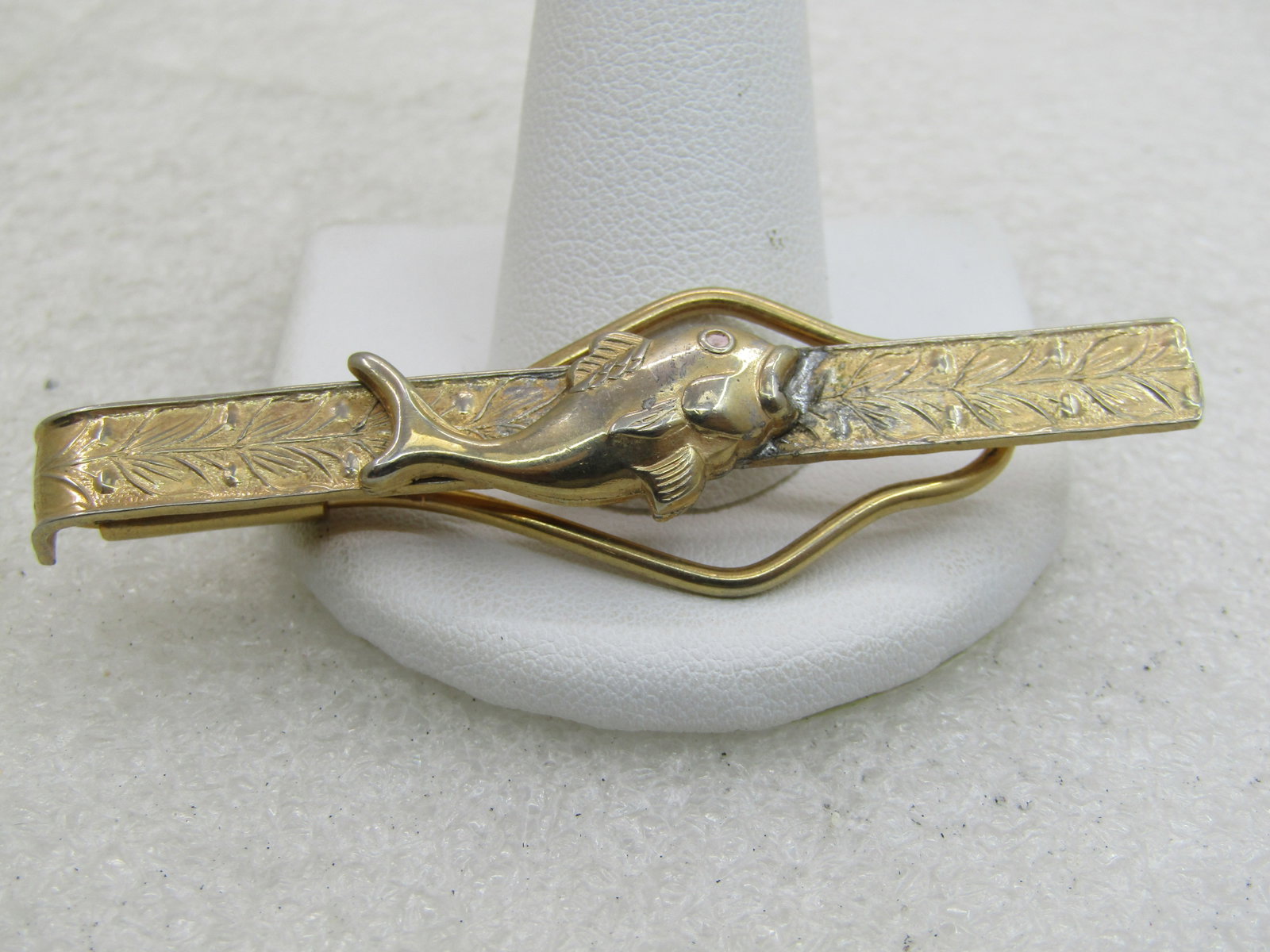 Vintage Gold Tone Fishing Tie Bar. 1940's-1950's, 2.5": Vintage Gold Tone Fishing Tie Bar. 1940's-1950's, 2.5" wide and appx. 3/4' tall at the center with the V accents. Textured tie bar with typical mid-century design and an applique fish - there is a lit