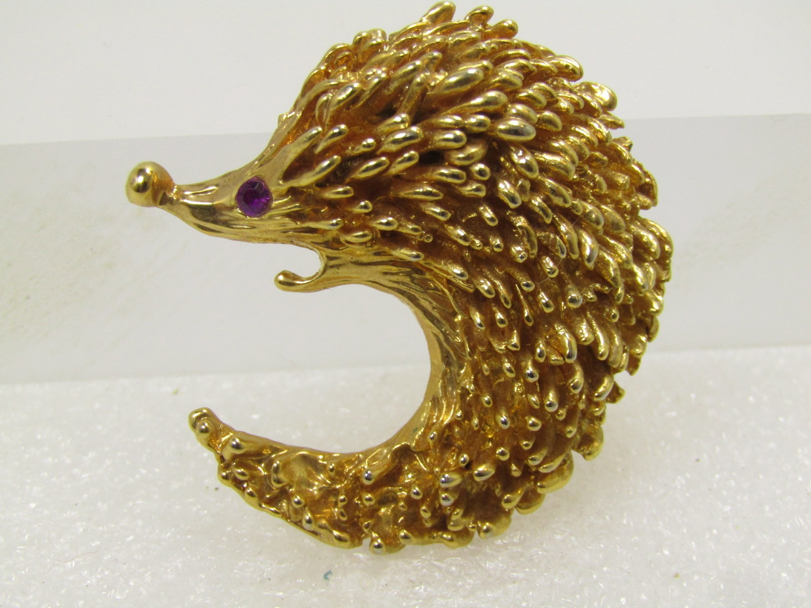 Vintage Hedgehog Brooch, Rhinestone Eye, 1980's: Vintage Hedgehog Brooch, Rhinestone Eye, 1980's. Gold tone with spikey fur that sticks up, in a curved position with a textured but less furgy face and inner body. It is appx. 1.5" tall and wide. Lock