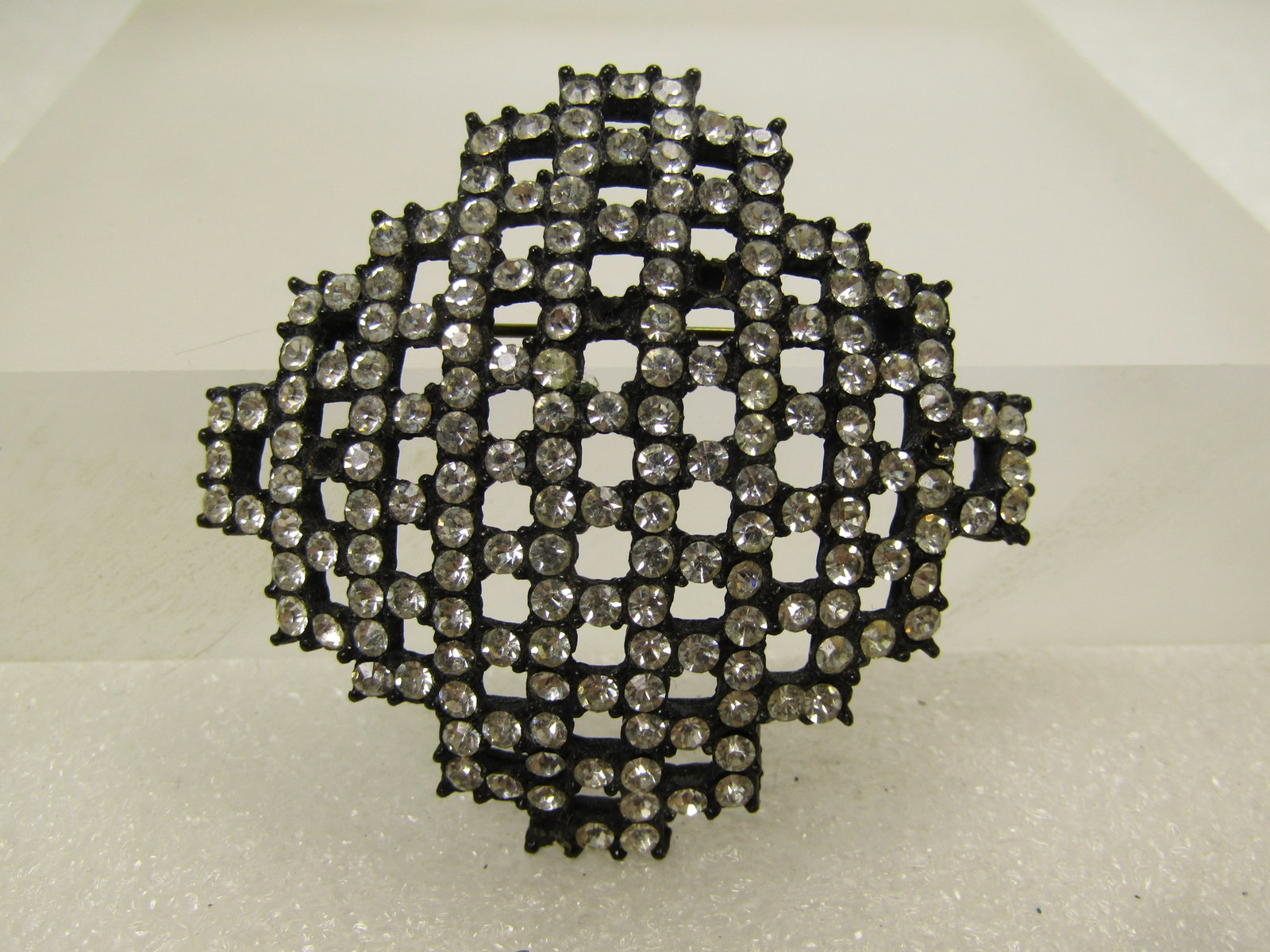 Vintage Black Metal Rhinestone Brooch, 1970's-1980's: Vintage Black Metal Rhinestone Brooch, 1970's-1980's. This has a black metal setting with all clear rhienstones set in an open and comed grid design. There are a few stones missing in the photos but