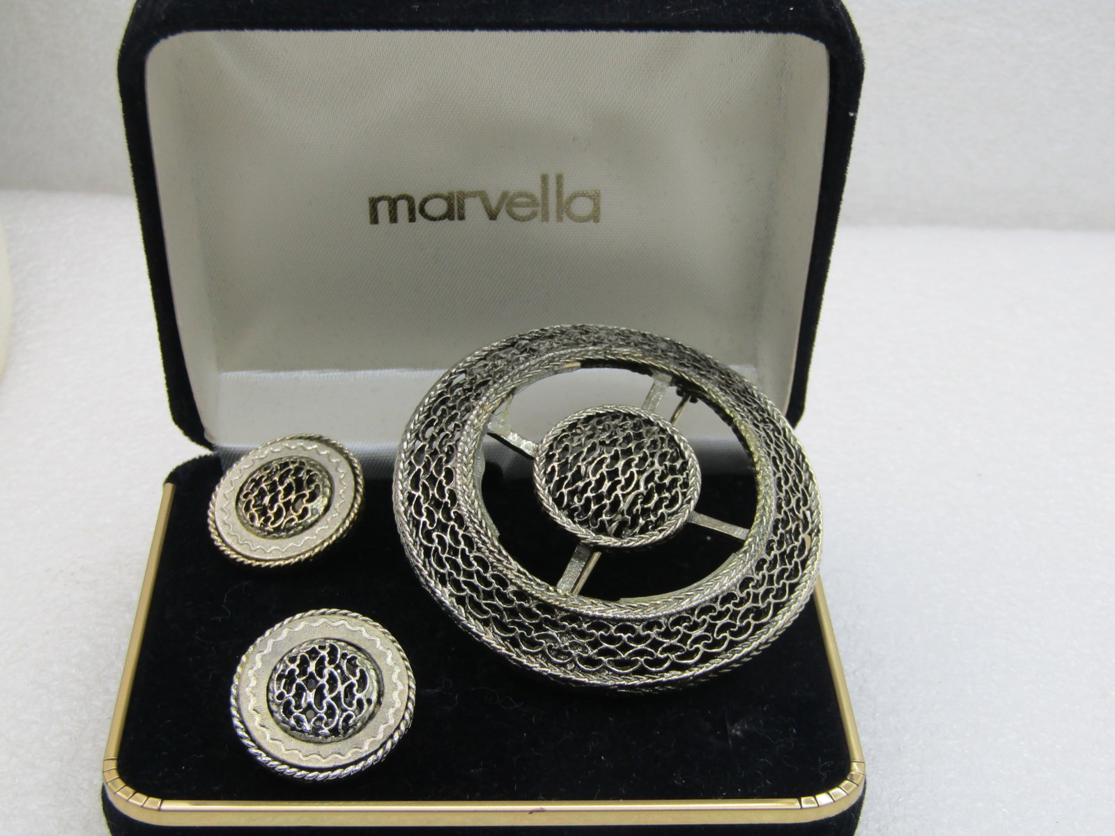 Vintage Marvella Brooch and Clip Earrings Set, in original box: Vintage Marvella Brooch and Clip Earrings Set, in original box which is signed Marvella on the lid. The brooch is appx. 2-3/8" across and has a woven frame angled frame with an open center with bars