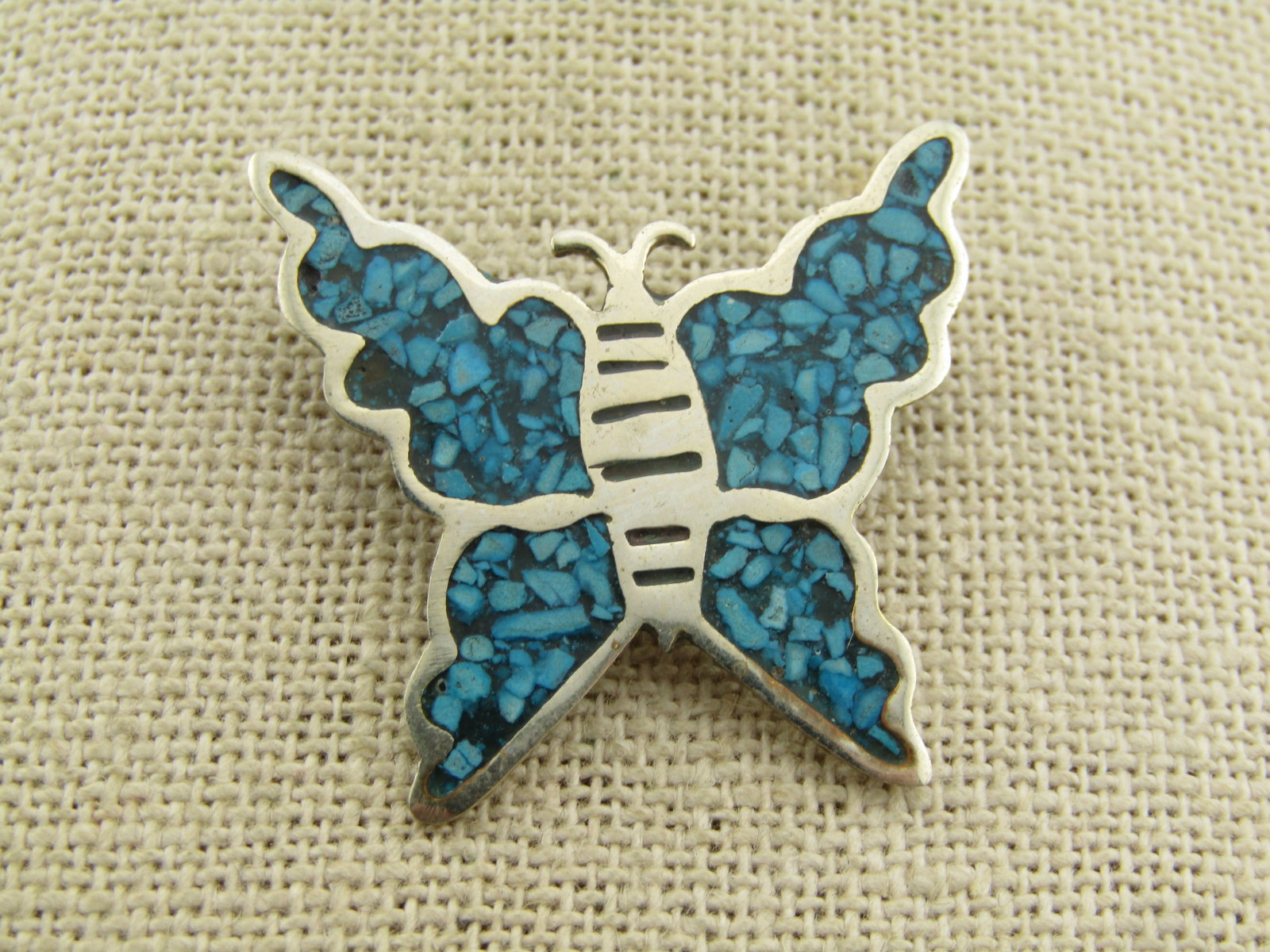 Vintage Butterfly Brooch, Mexico, Alpaca, Inlaid Turquoise Chips, 1970's-1980's: Vintage Butterfly Brooch, Mexico, Alpaca, Inlaid Turquoise Chips, 1970's-1980's. Ths butterfly brooch is approximately 1.25 inches tall and wide. Locking clasp. It is marked alpaca. Inlaid with what