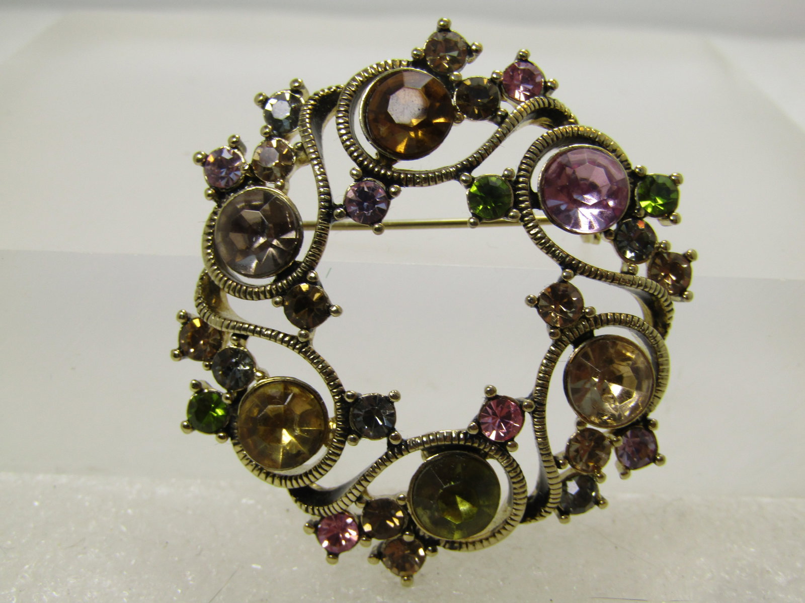 Vintage Monet Rhinestone Circle Brooch with Coils, 1980's-1990's: Vintage Monet Rhinestone Circle Brooch with Coils, 1980's-1990's. Gold tone with six curved and coil sections each with a larger rhinestone and three samller ones on the inside and a single one at top