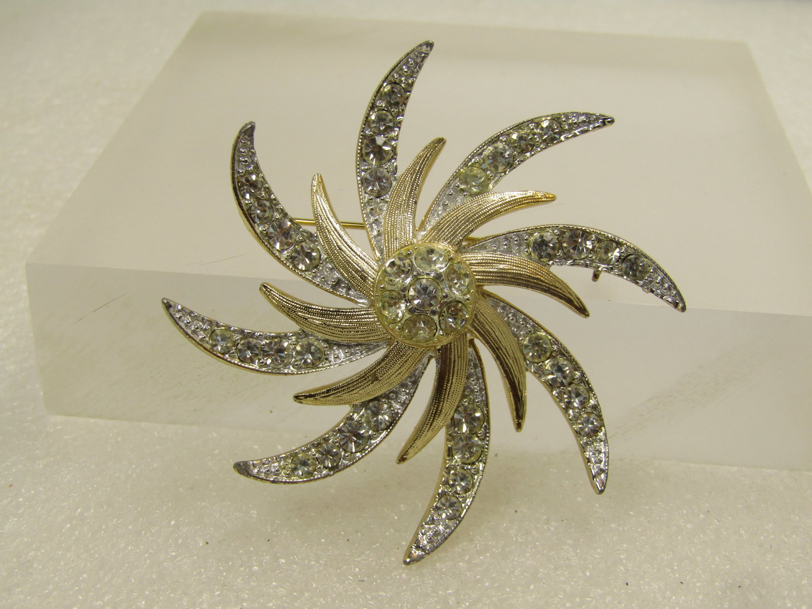 Vintage Pinwheel Rhinestone Brooch, Two-Tone, Sarah Coventry, 1960's-1970's: Vintage Pinwheel Spiral Rhinestone Brooch, Two-Tone, Sarah Coventry, 1960's-1970's. Mostly silver tone with pave-set rhinestones in the rays with textured gold tone shorter rays in the center and a