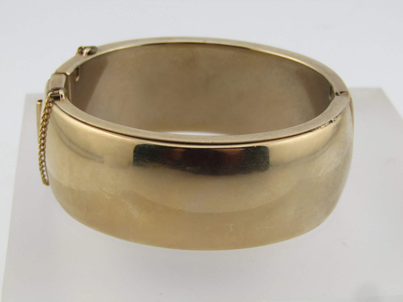Vintage Wide Hinged Cuff Bracelet, 6.5", 1960's-1970's: Vintage Wide Hinged Cuff Bracelet, 6.5", 1960's-1970's. Yellow Gold Tone. This is appx. 1" wide with safety chain and opening that is appx. 2.5" from side-to-side and 2" front-to-back. Easy-to-open