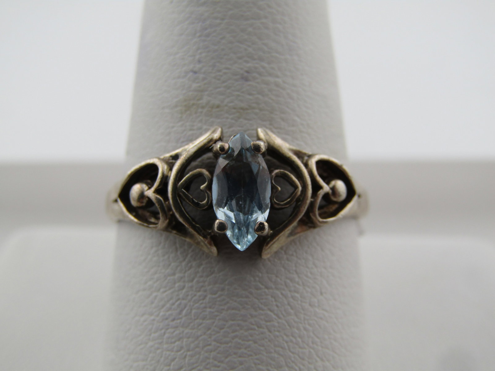 Vintage Sterling Blue Topaz Ring, Heart Scrolls, Sz. 10.25, 1970's-1980's, Signed: Vintage Sterling Blue Topaz Ring, Heart Scrolls, Sz. 10.25, 1970's-1980's, Signed D. It has a marquise light blue topaz stone that is appx. 8mm by 3.5mm. The ring is appx.8.8mm at top center going dow