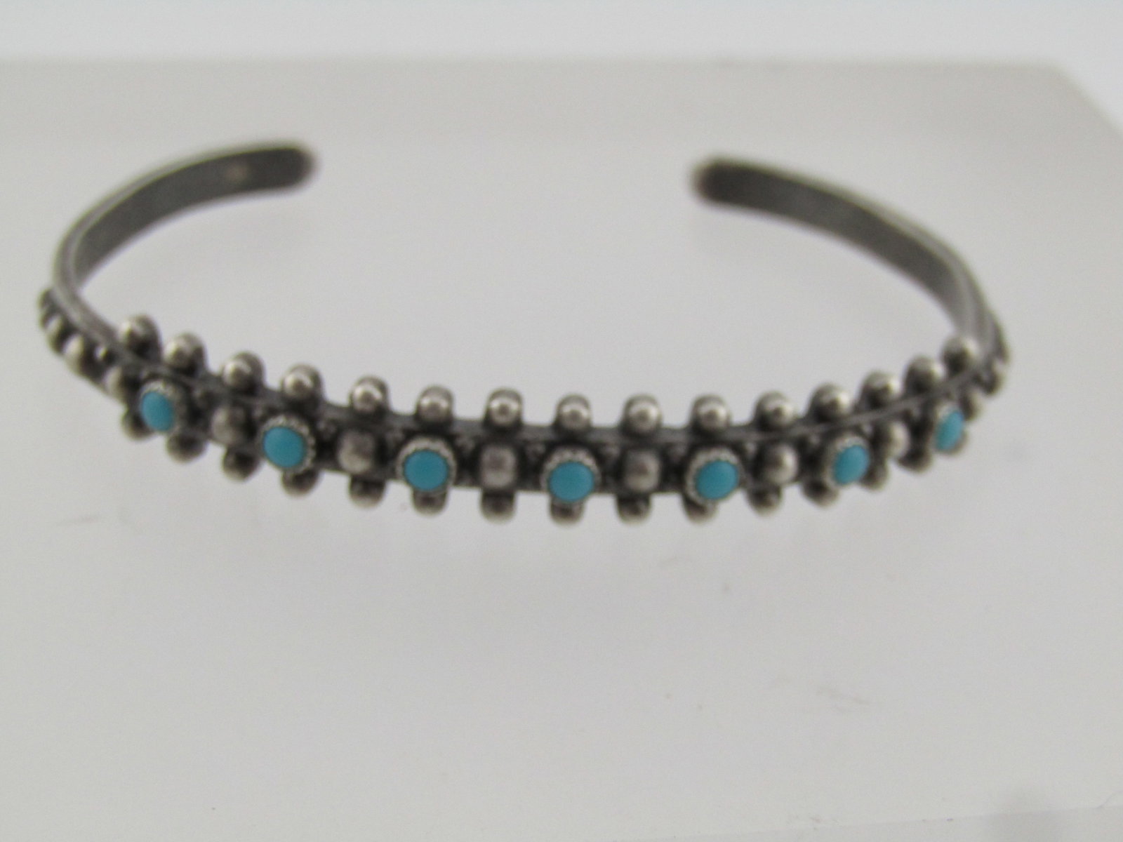 Vintage Sterling Southwestern Turquoise Cuff Bracelet, 6.5", 1960's-1970's: Vintage Sterling Southwestern Turquoise Cuff Bracelet, 6.5", 1960's-1970's. This has seven 2.5mm to 2.7mm snake eye turquoise cabochons that are bezel-set raised over the top center of the cuff with s