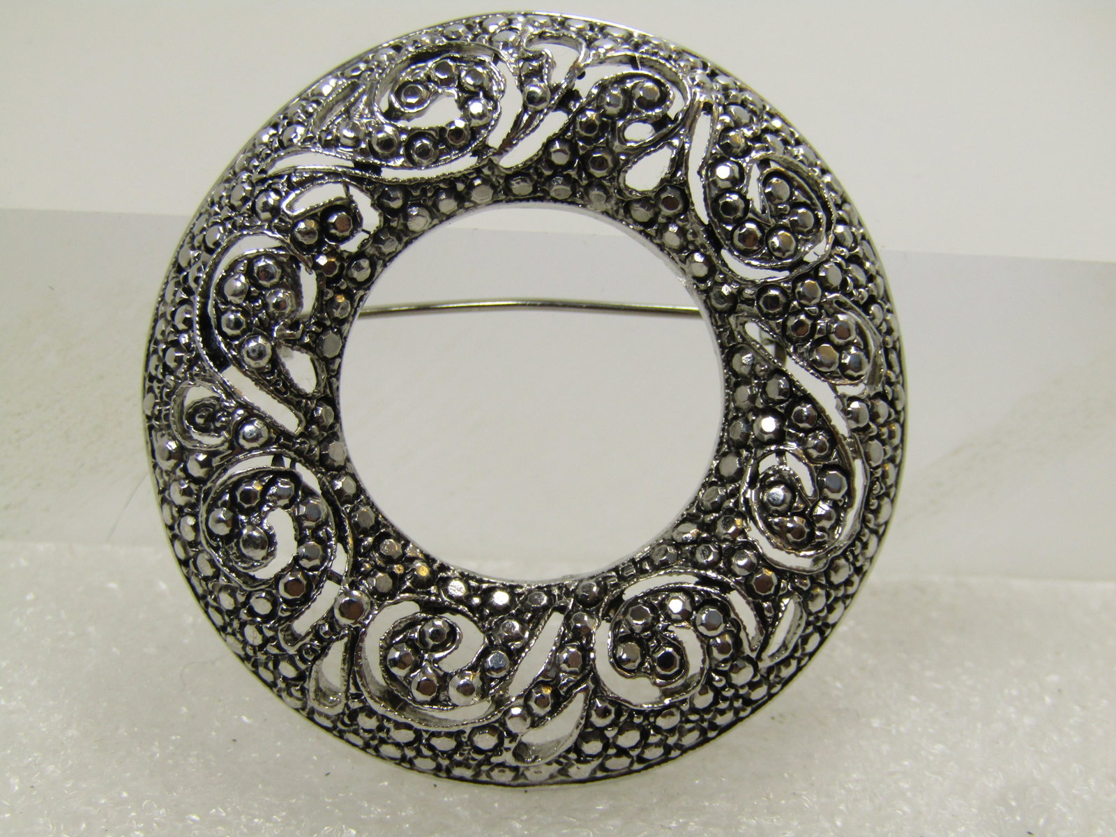 Vintage Faux Marcasite Circle Brooch, Domed, 1980's: Vintage Faux Marcasite Circle Brooch, Domed, 1980's. Silver tone brooch that is domed and appx. 1.75". It has scrolled and open work and the design looks like it is encrusted with marcasites - however