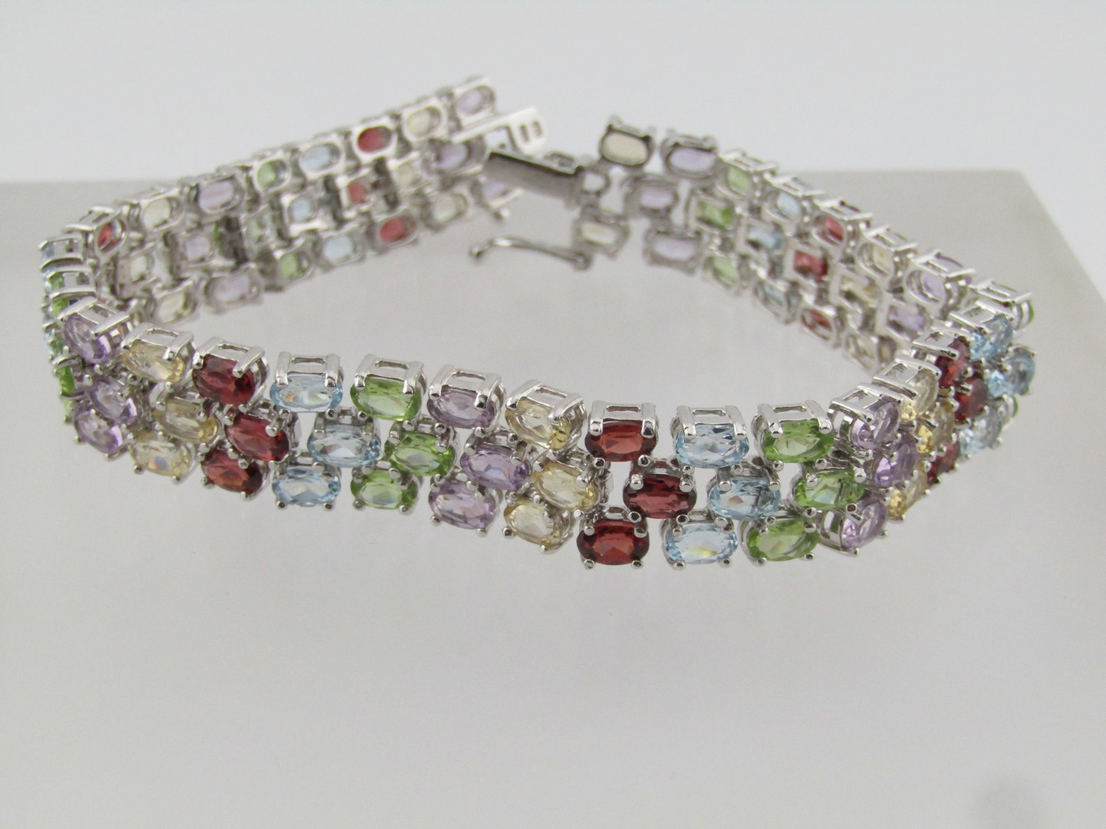 Sterling Mixed Gemstone Triple Strand Tennis Bracelet, 7", 1990.: Sterling Mixed Gemstone Triple Strand Tennis Bracelet, 7". This is marked .925 and tests as sterling with an appx. weight of 23.70 grams. It is signed FAS. It is appx. 11.5mm wide with a box clasp and