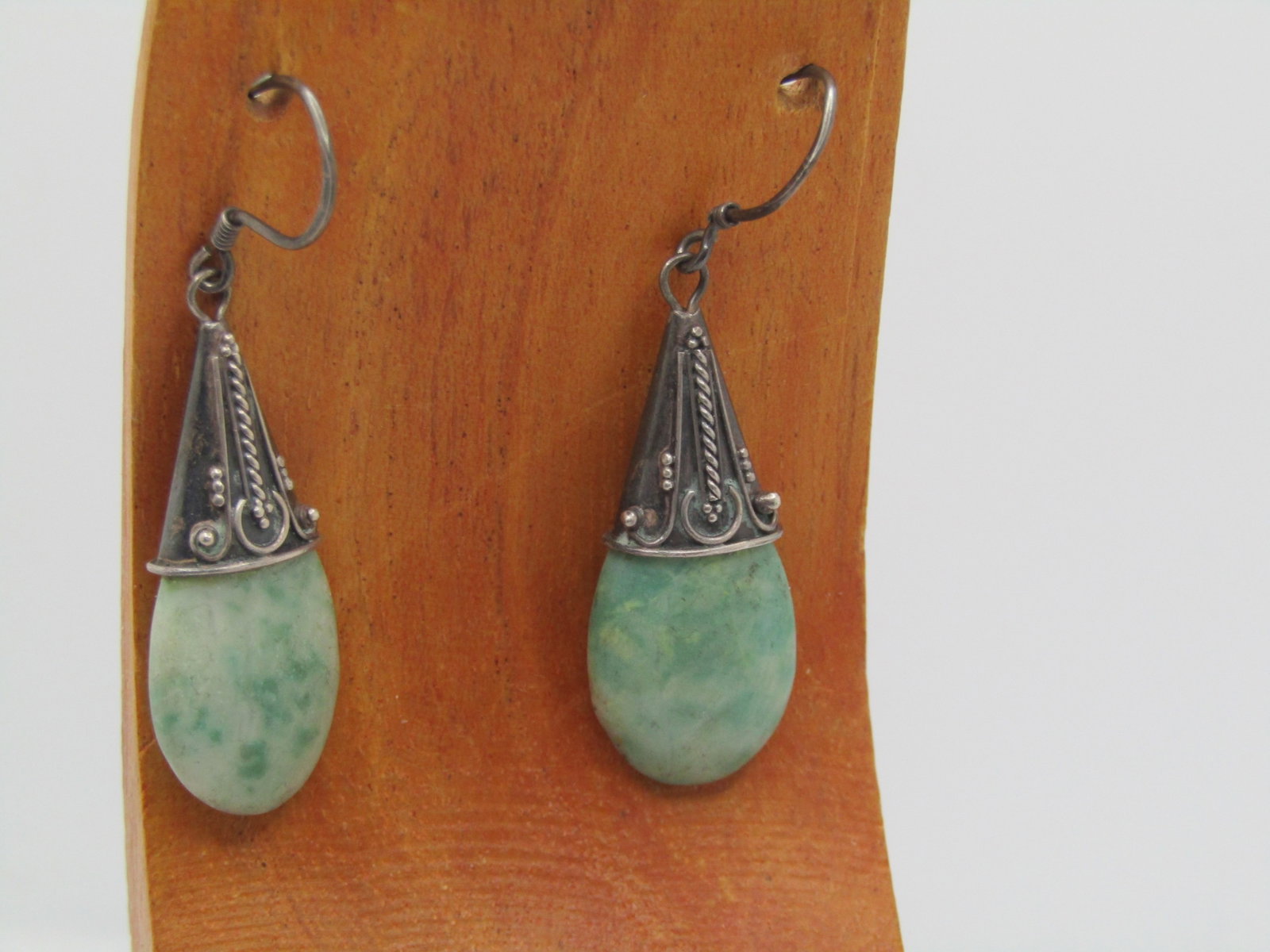 Vintage Sterling Green Stone Earrings, Pierced, Bali Themed, 1960's-1970's: Vintage Sterling Green Stone Earrings, Pierced, Bali Themed, 1960's-1970's. The earins have a dotted and scrolled top cap with a Bali theme. The stone is an oval green stone with white - likely
