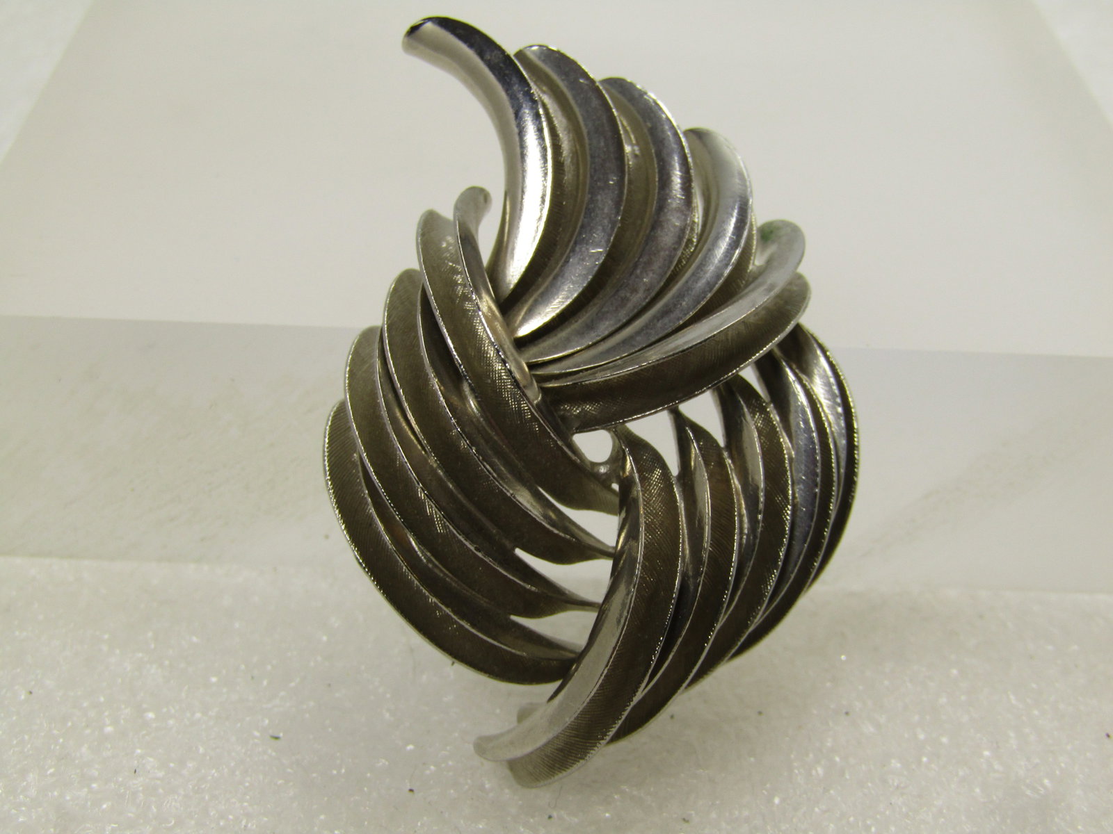 Vintage Wispy Curved Brooch, 1970's-1980's, Mod Design: Vintage Wispy Curved Brooch, 1970's-1980's, Mod Design. This is appx. 2.25" by 1.25" with raised edges and recessed centers on all the wispy features. Silver tone. Locking clasp. It is not marked or s