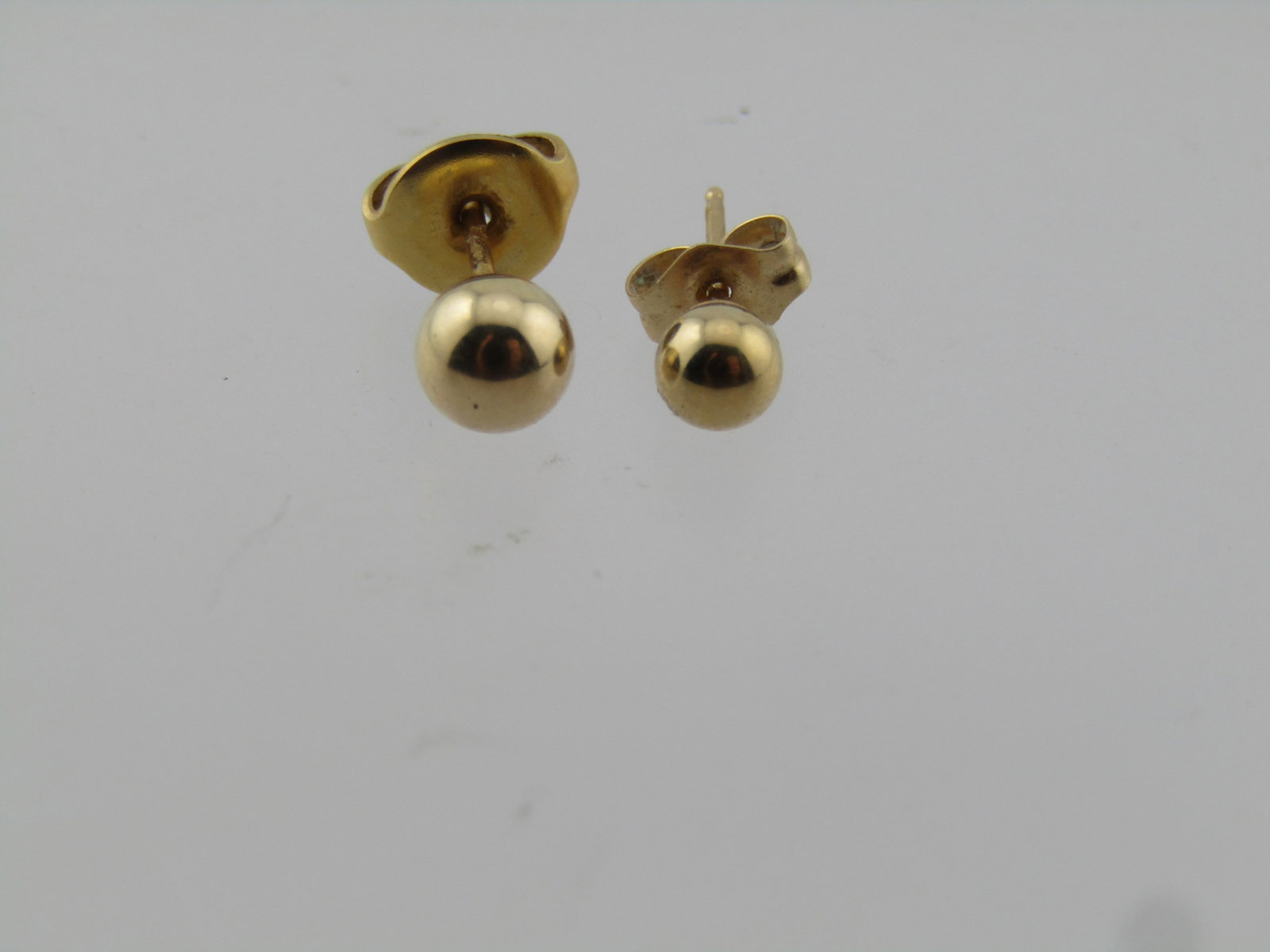 Vintage 14kt Gold Bead Earrings, Two Singles. 1960's-1980's: Vintage 14kt Gold Bead Earrings, Two Singles. 1960's-1980's. Yellow 14kt gold earring but one is a 3.5mm and the other a 4.9mm. The larger earring - the butterfly clasp is not gold. It is on the small