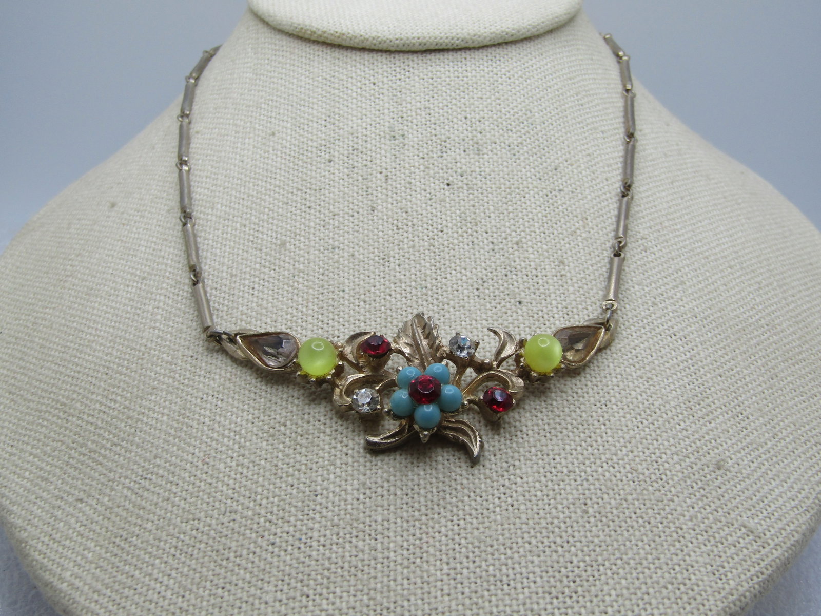 Vintage Rhinestone Floral Necklace, V-Drop, 1950's, 16": Vintage Rhinestone Floral Necklace, V-Drop, 1950's, 16". Gold tone bar link chain with flip clasp. The front drop is appx. 2-5/8" wide with a 2" drop at the front center. It has a faux turquoise bloss