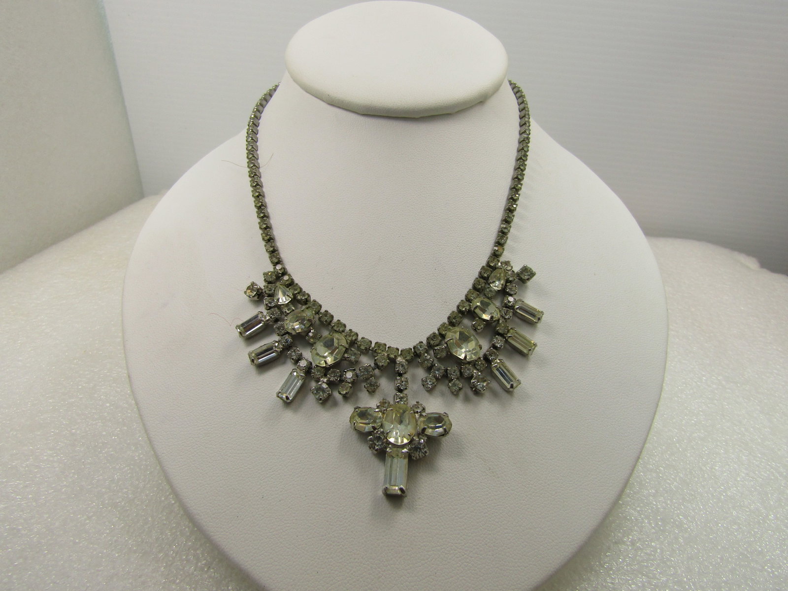 Vintage Rhinestone Clear Necklace, Oval/Round/Baguettes Bib, 15", Signed Weiss, Mid-Century: Vintage Rhinestone Clear Necklace, Oval/Round/Baguettes Bib, 15", Signed Weiss, Mid-Century. This has a hook clasp with a rhinestone on the top. It is signed Weiss. There is some finish wear on the