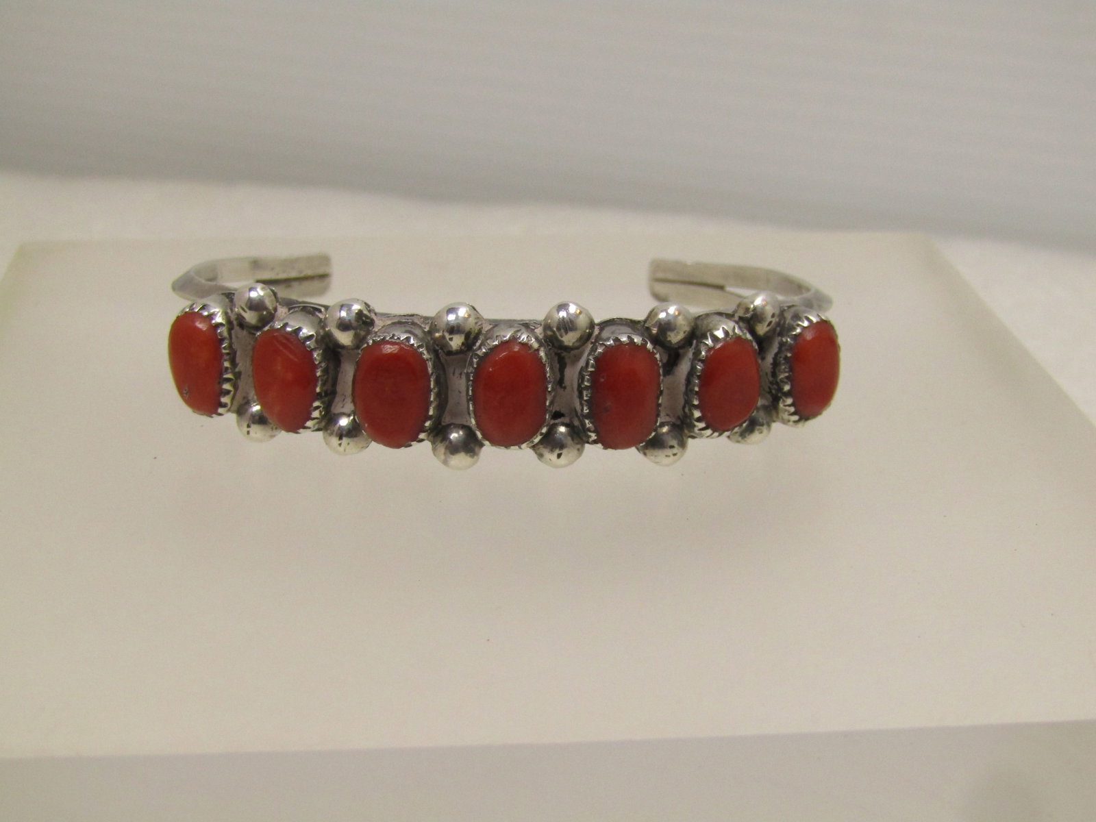 Vintage Sterling Southwestern Coral Cuff Bracelet, 6", 1960's-1980's: Vintage Sterling Southwestern Coral Cuff Bracelet, 6", 1960's-1980's. This has seven oval, appx. 8mm by 6.5mm cabochons set in a sawtooth bezel setting with an appx. 4mm round bead between each