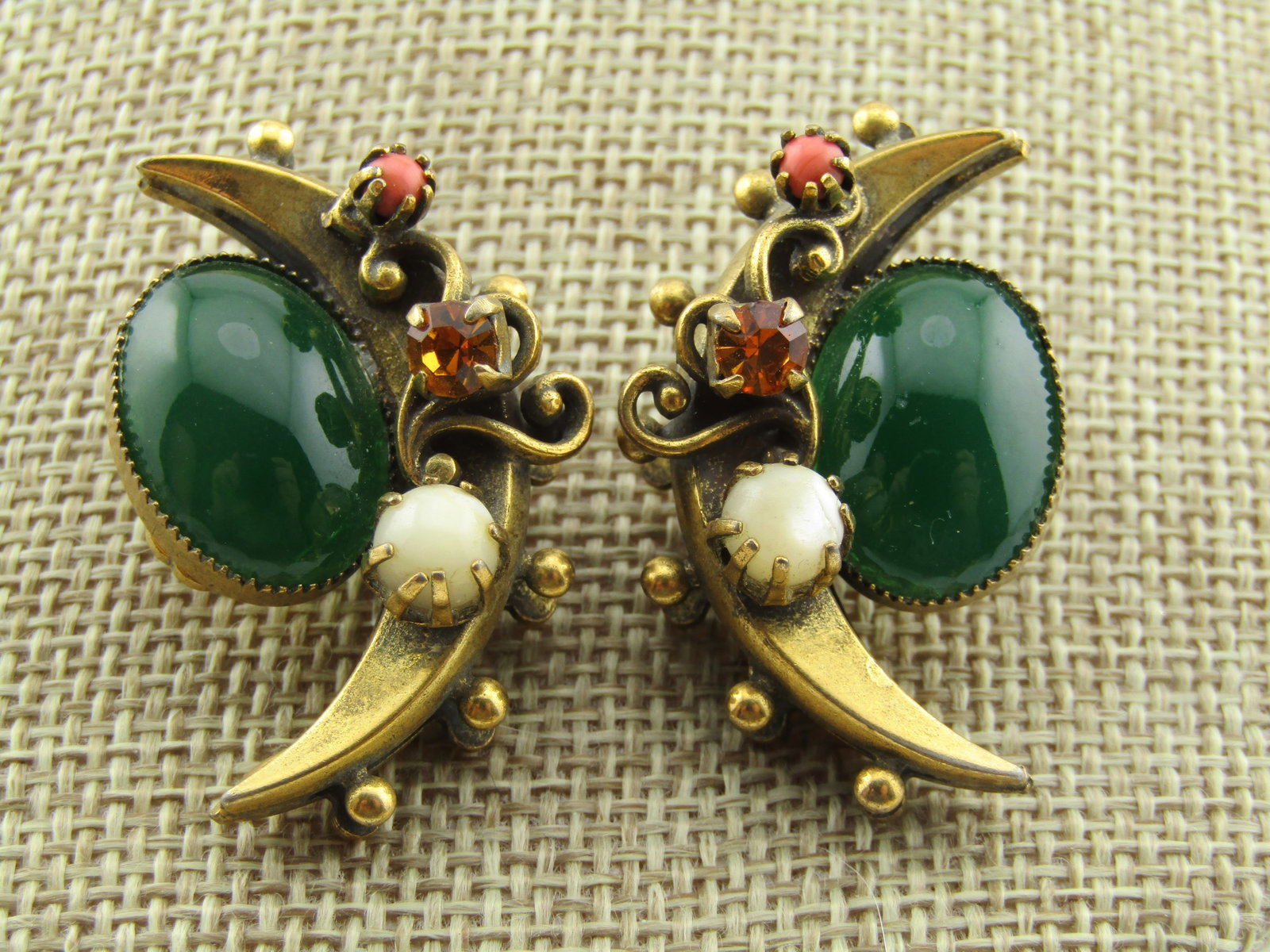 Vintage Victorian Revival Crescent Moon Clip Earrings, 1950's: Vintage Victorian Revival Crescent Moon Clip Earrings, 1950's. These are a brassy gold tone with a green faux emerald cabochon that is sawtooth bezel set and is set the inside of the crescent. The