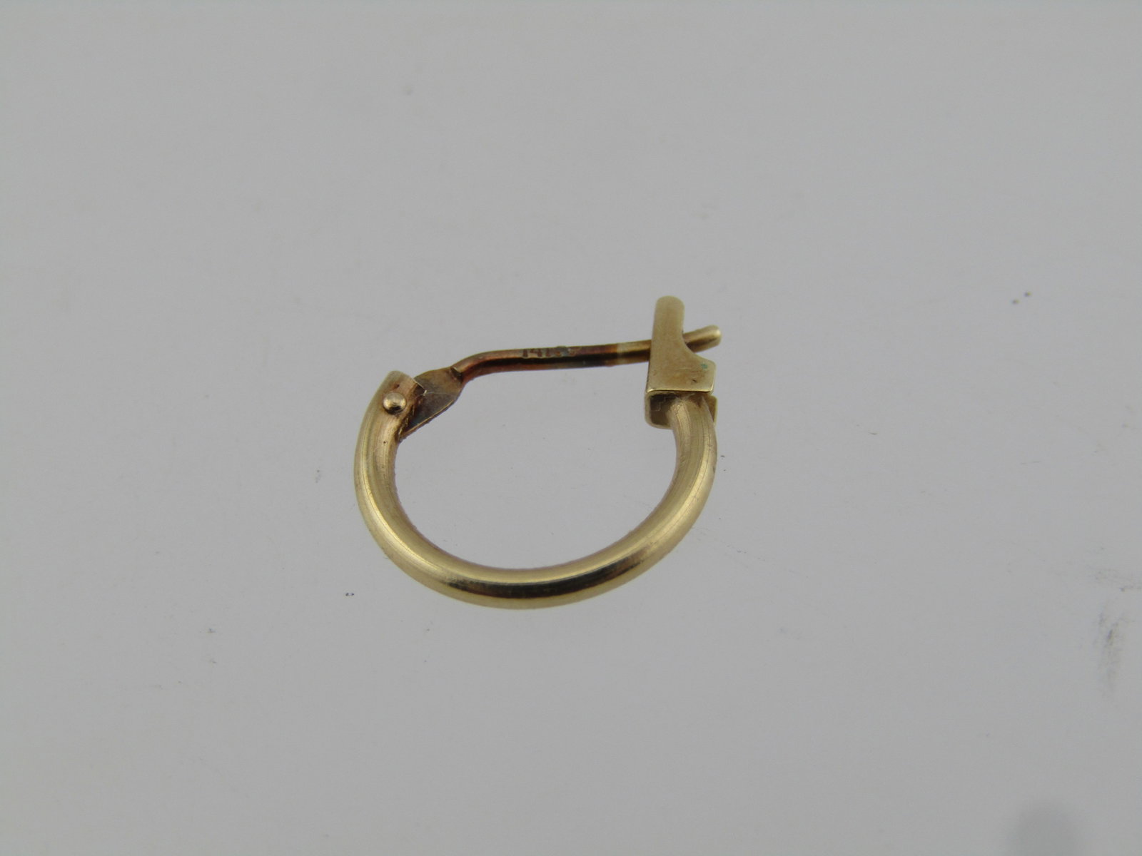 Vintage 14kt Petite Hoop Single Earring, Pierced, Youth/Infant Too, 1970's-1980's: Vintage 14kt Petite Hoop Single Earring, Pierced, Youth/Infant Too. 14kt yellow gold with hinged locking post. This is appx. 1/3" or 9mm by 9.5mm. . It is marked 14kt and has a maker's mark I cannot