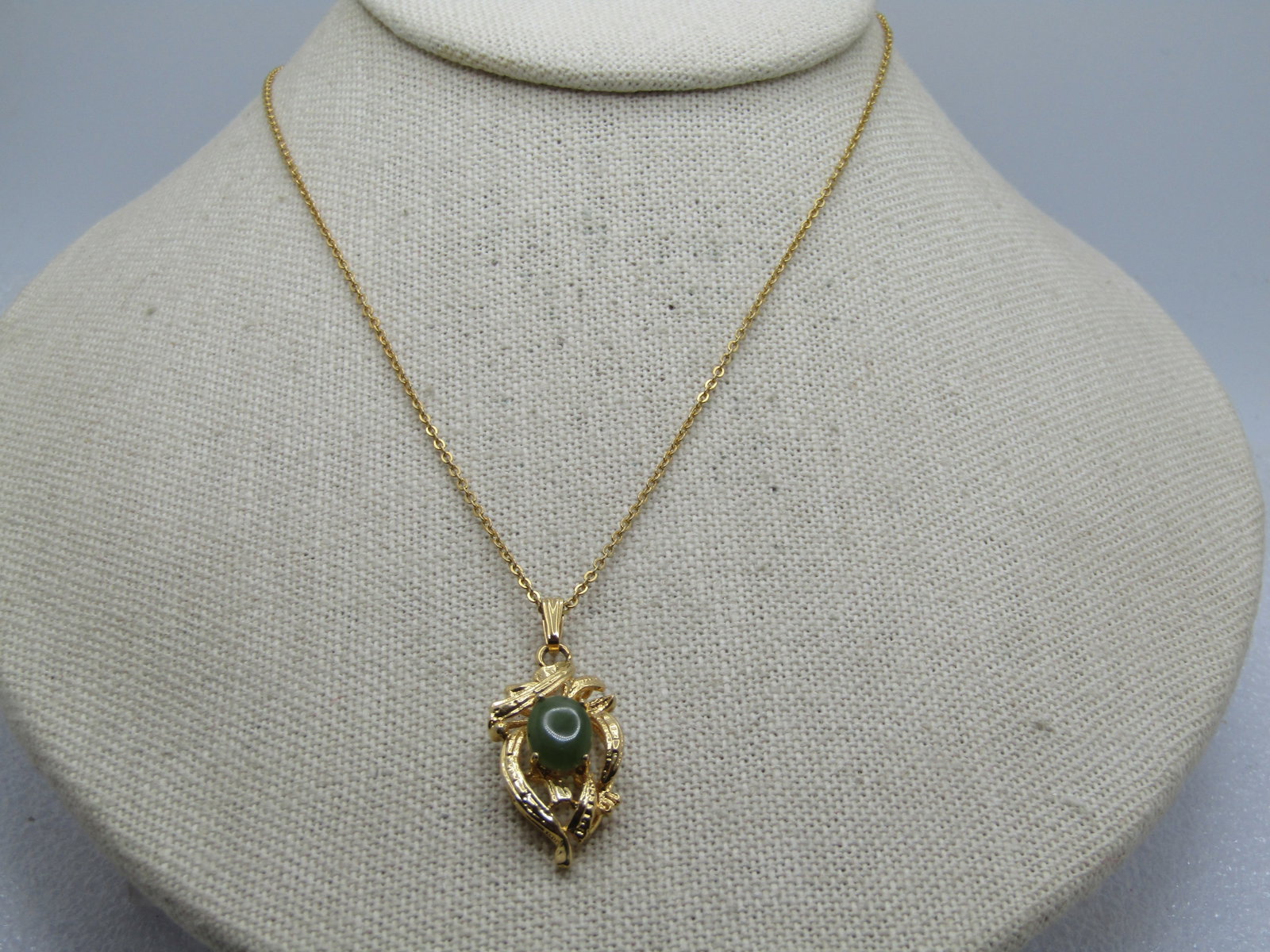 Vintage Jade Necklace, 20", Signed SN, 1980's: Vintage Jade Necklace, 20", Signed SN, 1980's. This hs a textured randomly scrolled and curved pendant with a center jade stone that is oval and appx. 8.5mm by 6.5mm. Gold tone chain with spring clasp
