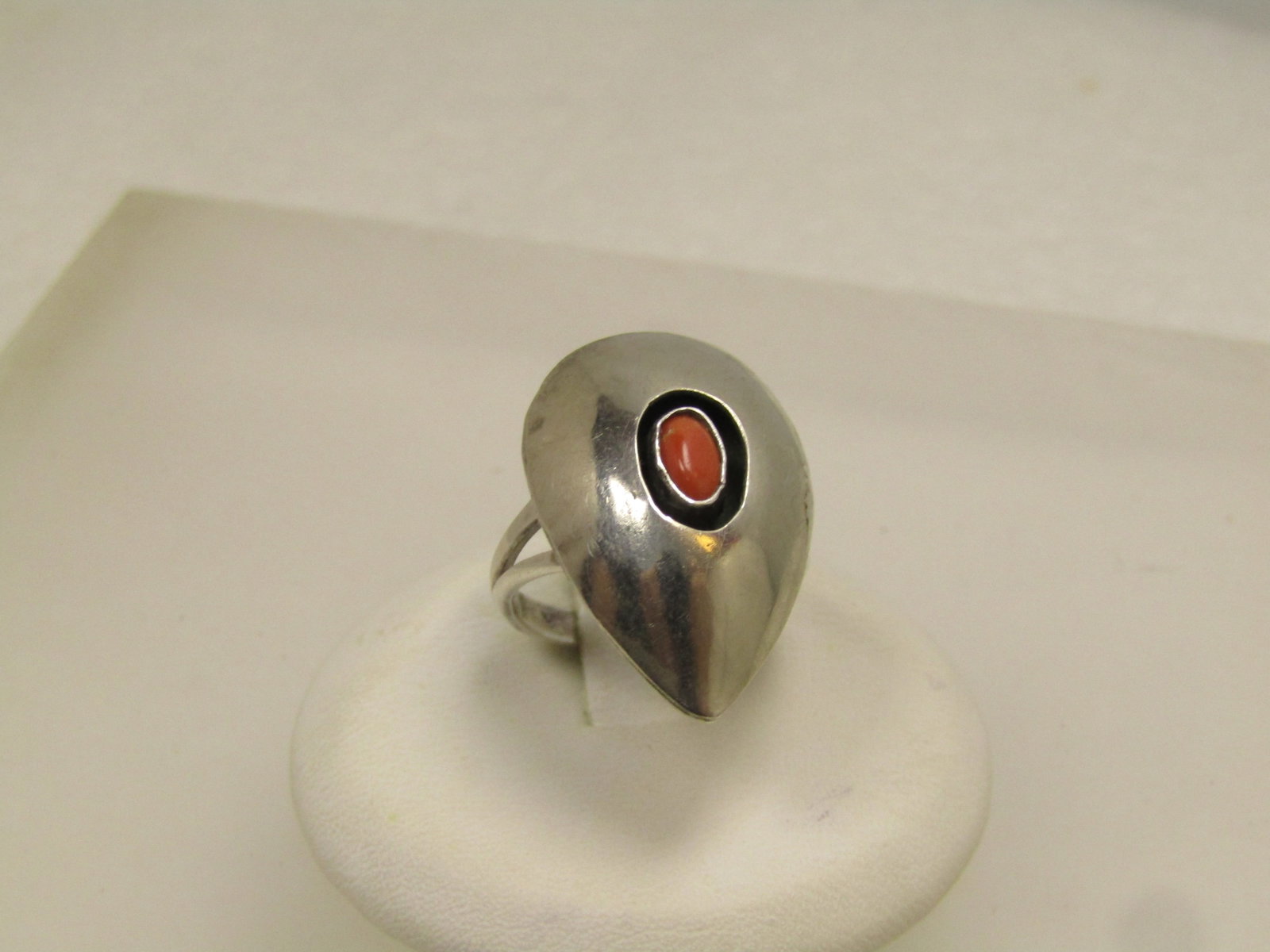 Vintage Sterling Southwestern Coral Ring Sz. 5, 1960's-1970's: Vintage Sterling Southwestern Coral Ring Sz. 5, 1960's-1970's. Shadowbox with recessed area - oval - around the appx. 5.5mm by 4mm oval bezel-set coral stone. The ring is doned on top and a pointed