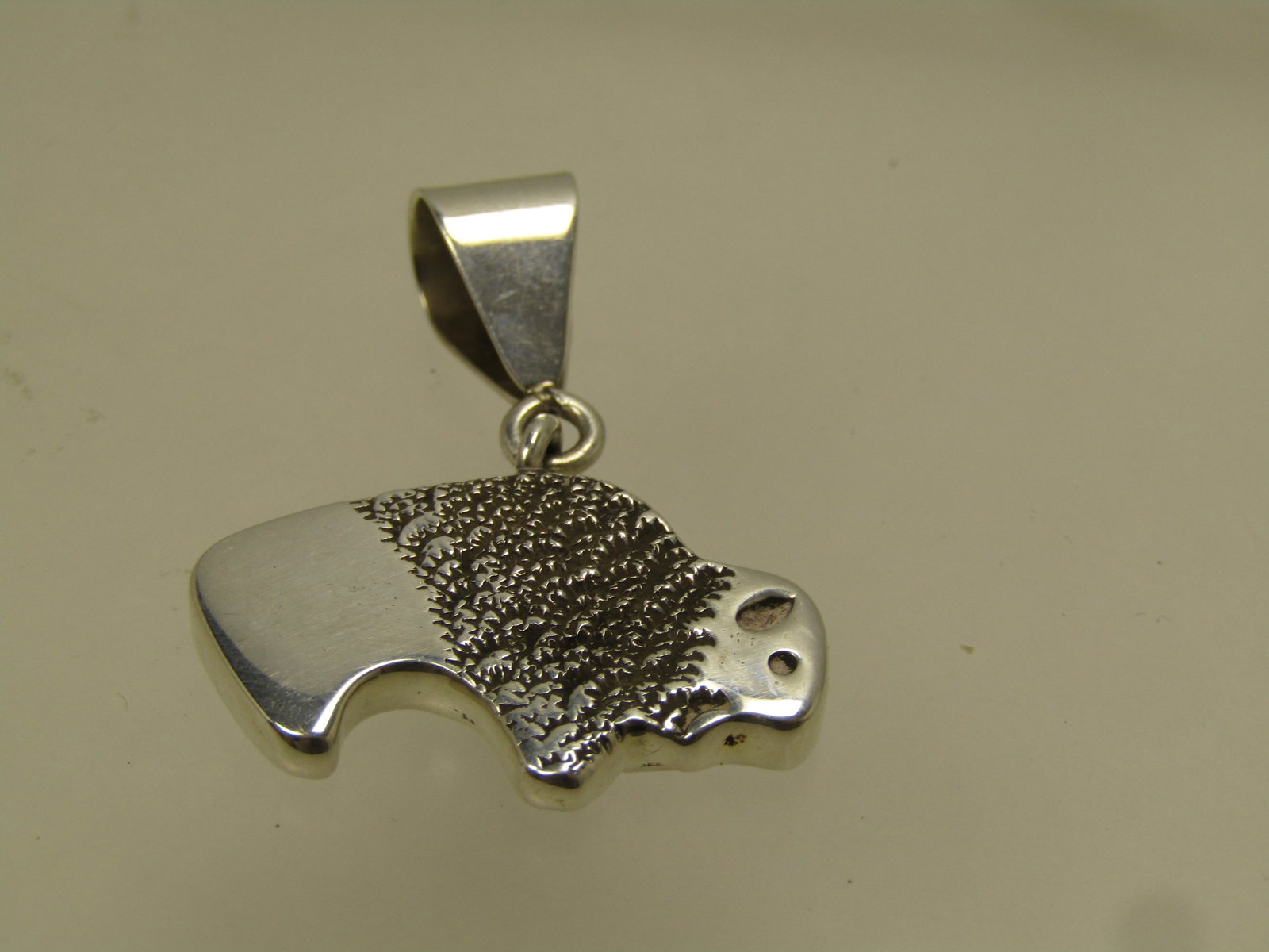Vintage Sterling Buffalo Pendant, Two-Sided, Signed NW, 1980's-1990's: Vintage Sterling Buffalo Pendant, Two-Sided, Signed NW, 1980's-1990's possibly slightly earlier. The maker's mark of NW is unknown. This is marked sterling and tests as sterling with a weight of