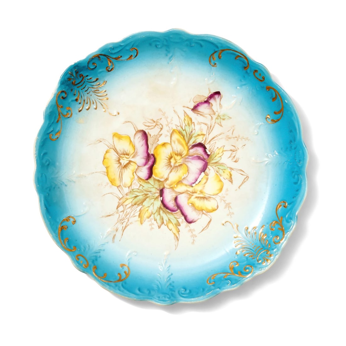 Decorative Dish: Charming decorative dish featuring scalloped rim and vibrant design of pansies at its center. The dish is adorned with blue border that fades to white towards the center. Disclaimer: This item is offe