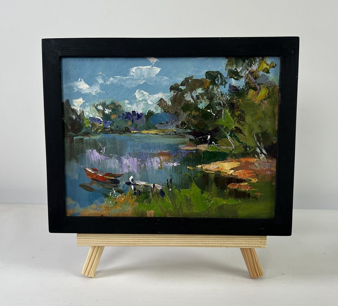 Oil painting River with boats along the shore Yuriy Suprunchuk: NoAAA5518The Oil painting on Cardboard titled "River with boats along the shore" captures a tranquil riverside scene where water, sky, and land merge into a harmonious composition full of light, color