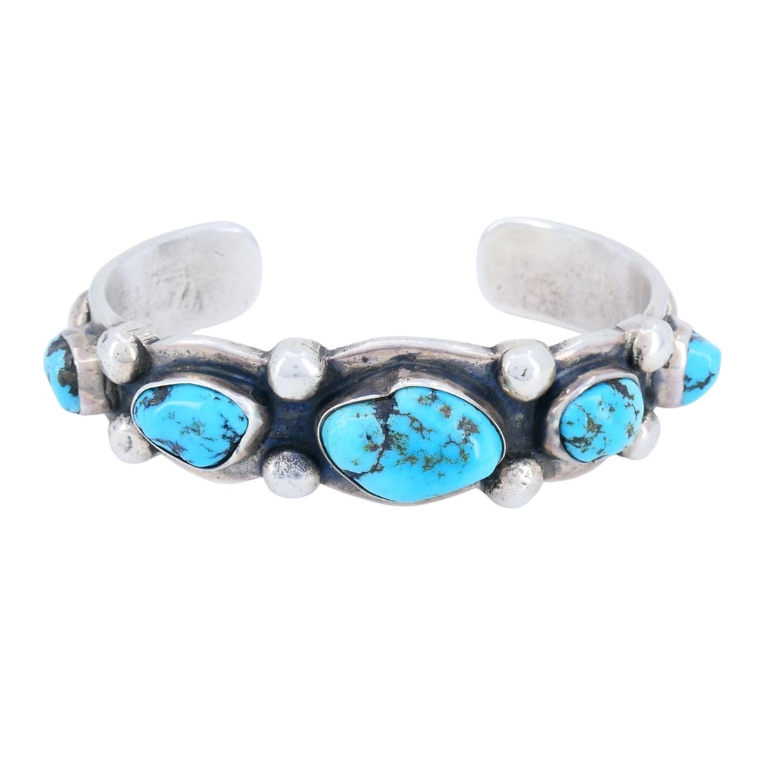 Vintage Navajo Native Indian Sterling Silver Turquoise Cuff Bracelet: KL NOO This vintage sterling silver turquoise cuff bracelet features a classic Southwestern Navajo design centered around a row of natural turquoise cabochons. The bracelet is constructed as a substan
