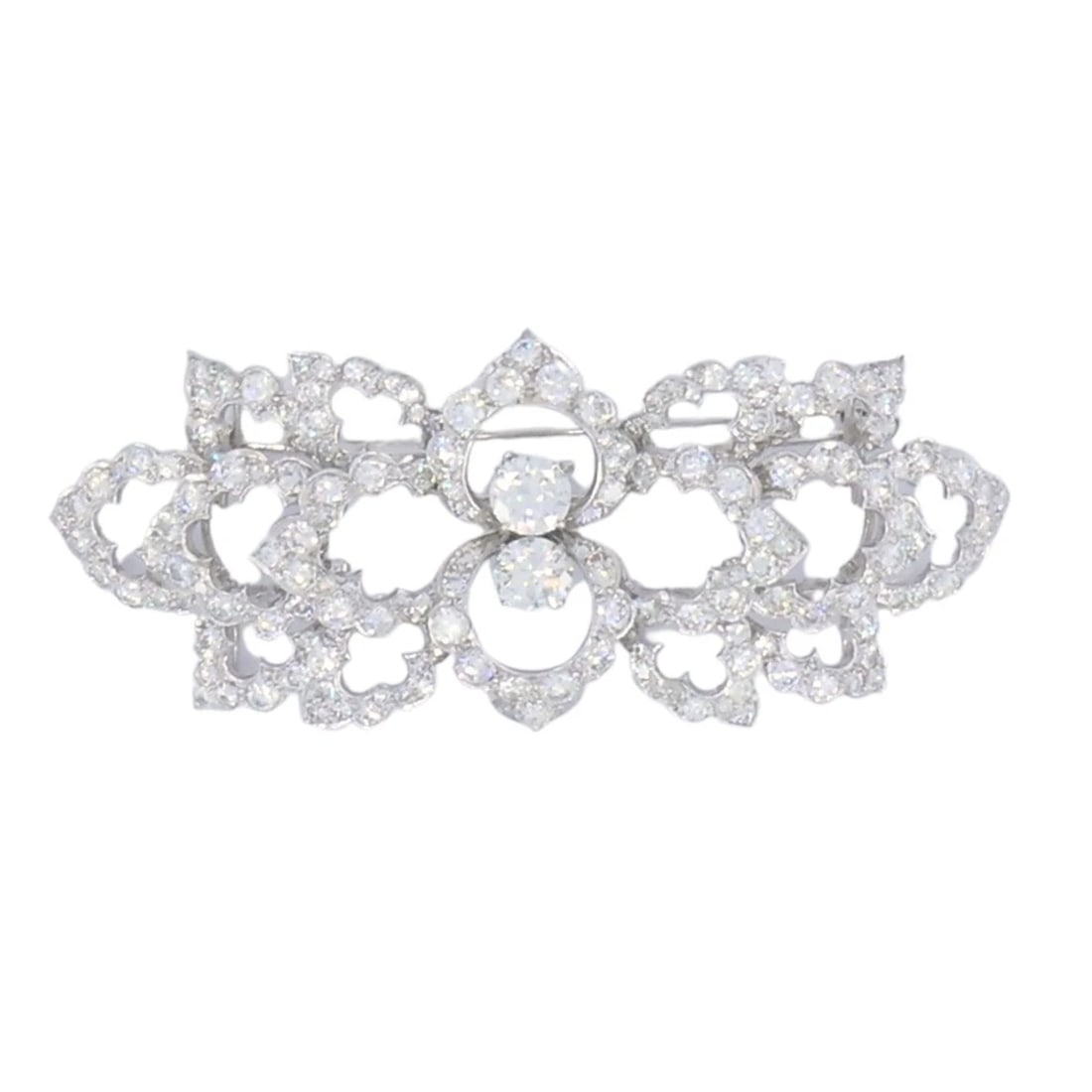 David Webb Diamond Platinum Brooch Floral Design: NS JJTOO David Webb Diamond Platinum Brooch Floral Design This vintage David Webb brooch is a refined example of the designer's work in platinum and diamonds. The piece features an openwork layout