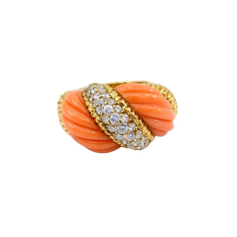 Vintage Coral Ring 18k Gold Diamond: NS UUTO Vintage coral ring, crafted of 18k gold, features diamond. The ring's centerpiece features two twisted, carved coral sections. A diagonal gold band, encrusted with round cut diamonds, runs acr