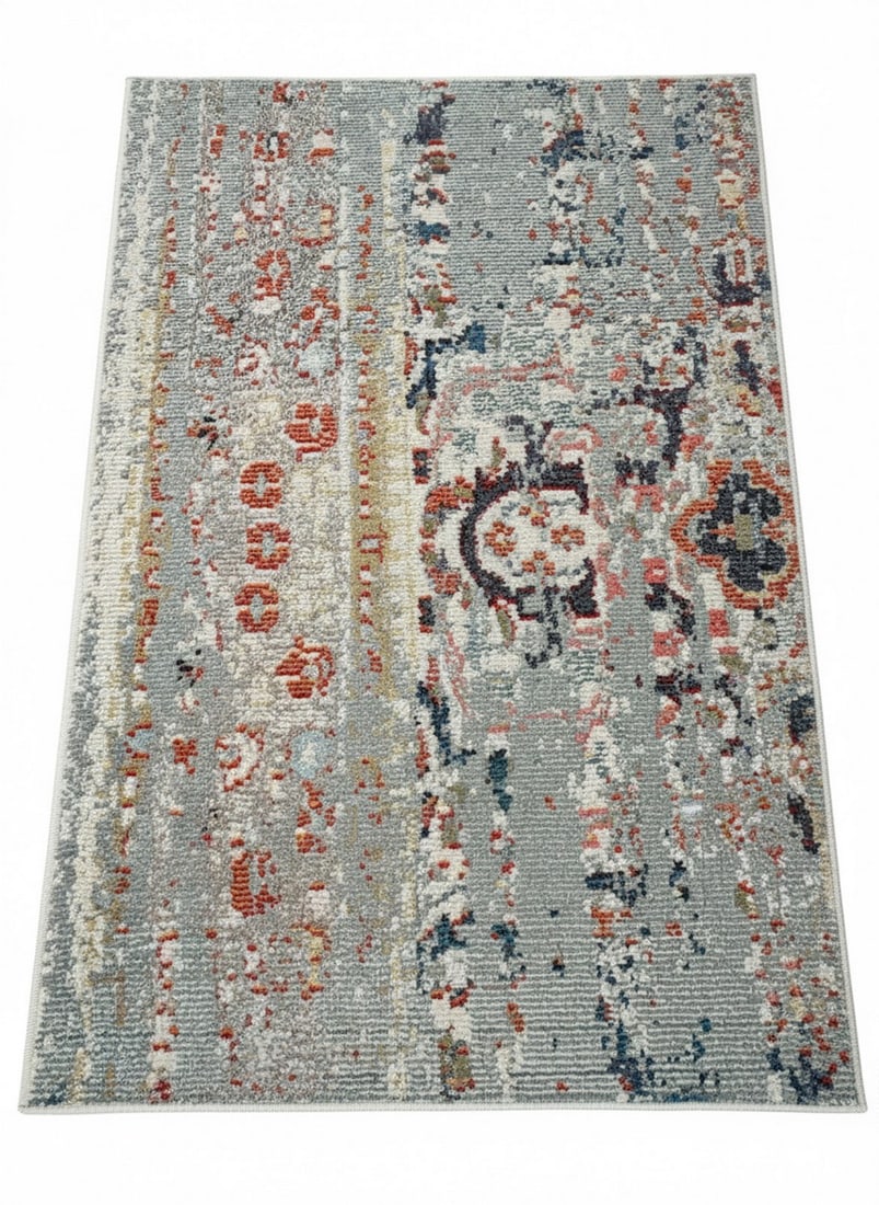 Contemporary Abstract Gray, Orange, and Blue Area Rug: A contemporary area rug featuring an abstract design with a light gray ground and distressed-look motifs in shades of orange, blue, cream, and red. The rug has a short pile and appears to be