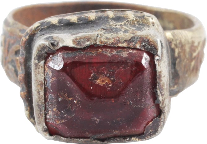 EASTERN EUROPEAN GYPSY RING, SIZE 8: White metal/base silver. Broad band, 5.4mm, flaring to the foliate decorated shoulders. Large rectangular bezel with pelleted base. Raised faceted red "stone" in tall bezel mount. Charming provincial