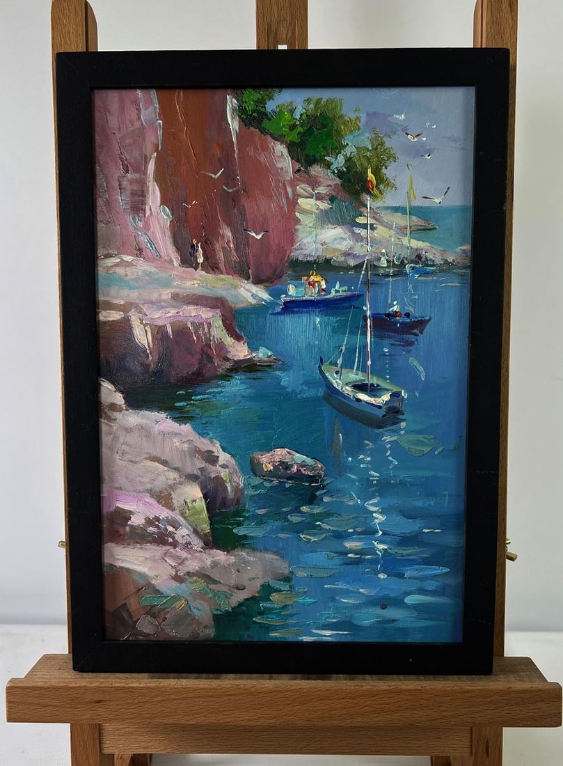 Oil painting Boats on the rocky shore Yuriy Suprunchuk: №AAA5537The Oil painting on Cardboard titled “Boats on the rocky shore” is a vivid celebration of the interplay between natural beauty and human presence, framed within a coastal lan