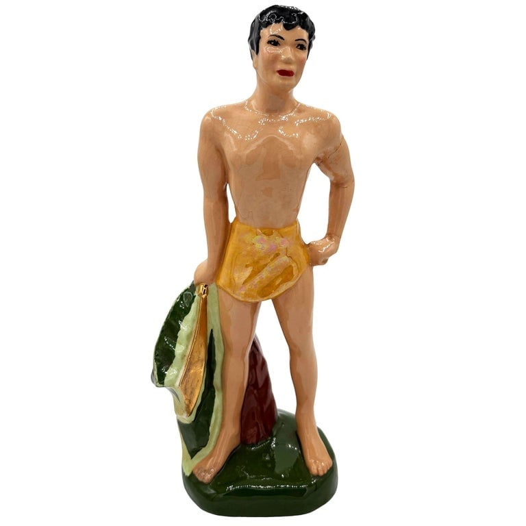 Mid-Century Hand Painted Native Surfer w/ Gold Machete Ceramic Sculpture: Original post-war ceramic Hawaiian native boy with gold Machete made from molded ceramic and hand painted in vibrant tropical colors. It depicts a young Native Hawaiian boy on a a grassy field with ye