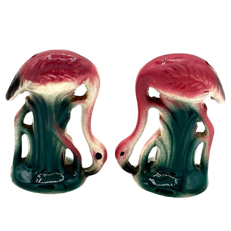 Mid-Century Pink Flamingo Ceramic Tabletop Matching Salt and Pepper Shaker Set: Mid-century pink and green ceramic flamingo tabletop salt and pepper shaker set. The set features two beautifully detailed pink flamingos in lush green leaves and grass. Unsigned Measurements: 4"
