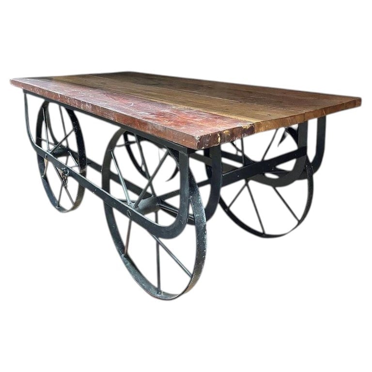 Industrial Iron and Wood Railroad Style Rolling Trolly Cart Coffee Table: Iron and reclaimed wood coffee table fashioned after the railroad trolly carts of yesteryear showcases a captivating mix of multi-colored wood elements that create a rich, patchwork effect. The