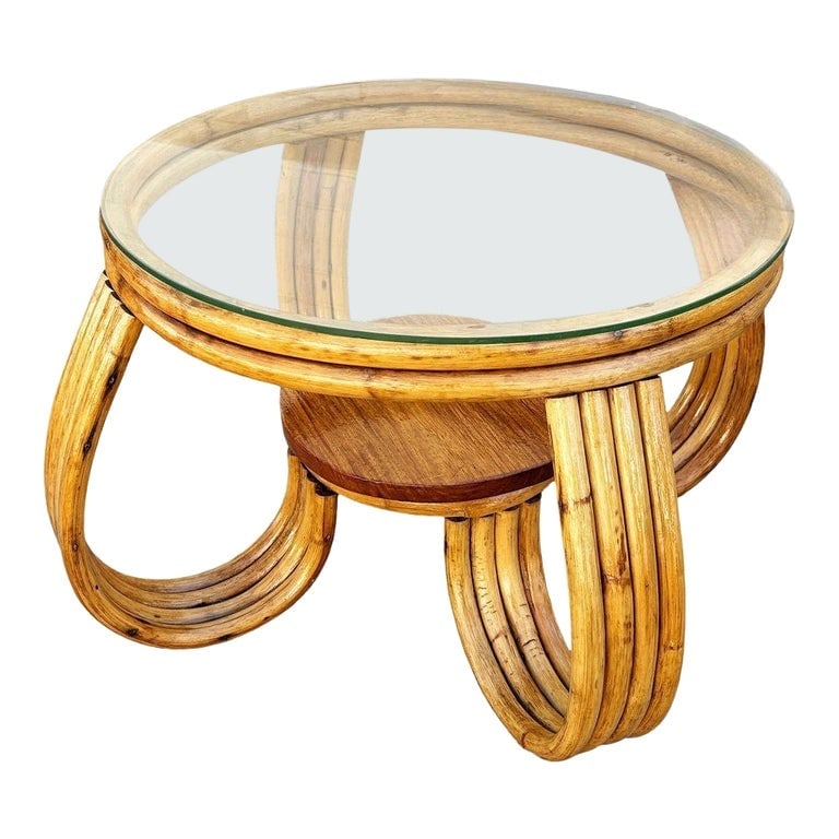 Restored Rattan Three-Strand Loop Leg Coffee Table: A striking Mid-Century Modern rattan coffee table features elegantly curved bent rattan legs, a circular glass top, and a center wood shelf for added function. Beautifully restored, showcasing the war