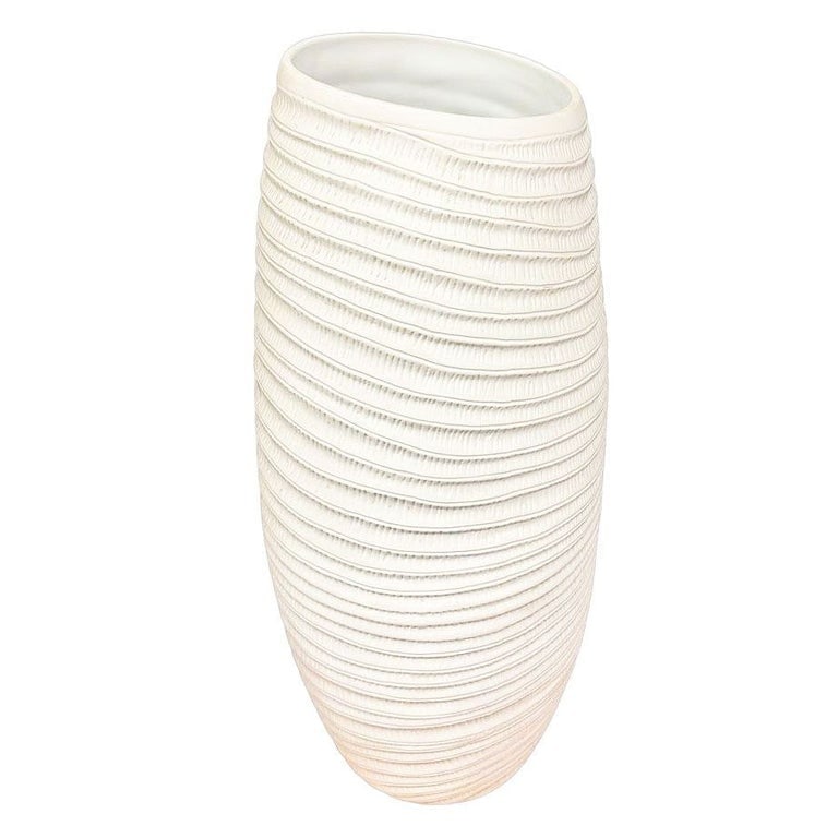 Ribbed Textured Coiled "Coco" Ceramic Vase w/ Matte Finish by Bahari: Ribbed Textured Coiled ceramic Vase by Bahari is a white, ribbed, barrel-shaped vessel, shaped with cascading ridges, and the subtly ribbed terracotta creates a dynamic shape perfect for displaying