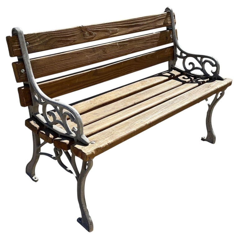 Restored Victorian Cast Iron and Wooden Lath Garden Bench w/ Vine Leaf Detail: Vintage outdoor benches featuring natural wood slats and elegant cast iron frames with scrolling arm details. The combination of warm wood tones and silver-painted metal adds timeless charm and durabi