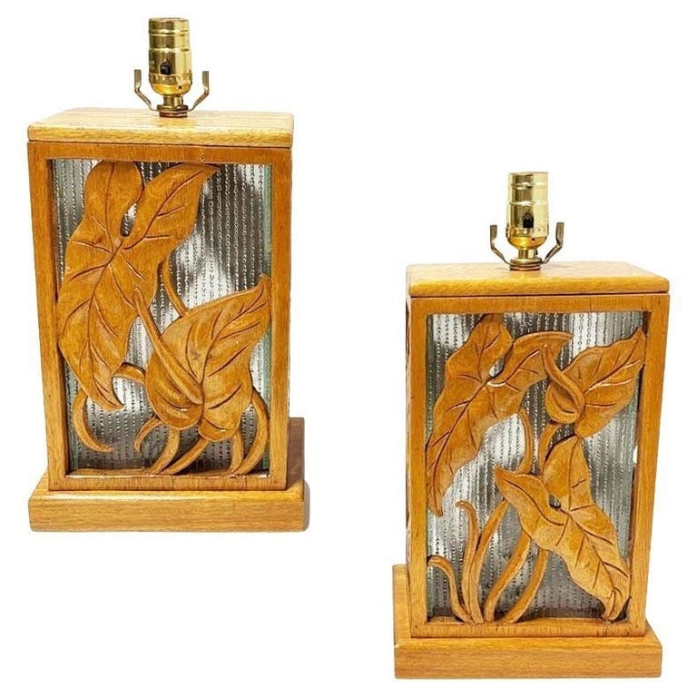 Restored Mid-century Hawaiian Carved Mango Wood Panel Lantern Table Lamps, Pair: A striking pair of mid-century table lamps hand made in Honolulu, Hawaii featuring beautifully carved wood panels with flowing botanical leaf motifs set against textured glass backdrops. The warm hone