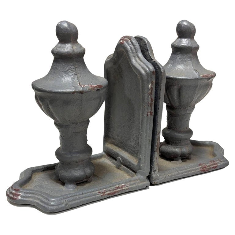 Grey Colonial Style Cast Iron Enamel Grey Finial Bookend, Pair: Cast iron grey bookends showcase a traditional aesthetic with intentional antiquing and paint chips that exude vintage charm. The weathered finish adds character and warmth, making them both functiona