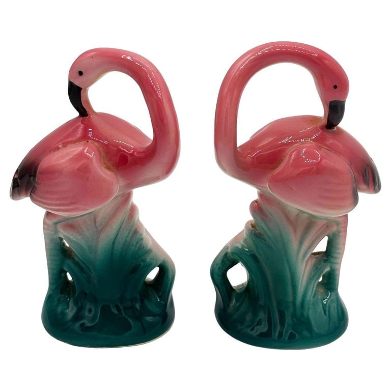 1980 Pink Flamingo Ceramic Tabletop Salt and Pepper Shaker Set by Sarsaparilla: Mid-century pink and green ceramic flamingo tabletop salt and pepper shaker set by Sarsaparilla from the 1980s. The set features two beautifully detailed pink flamingos in lush green leaves and grass 