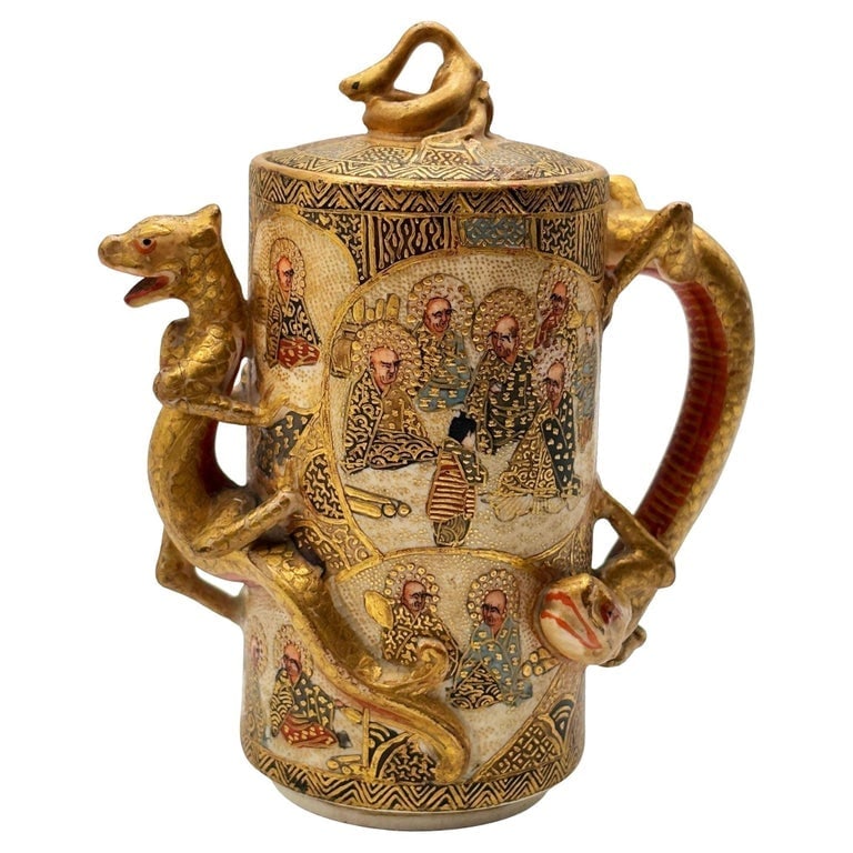 Gyokushu Satsuma Earthenware Saki Pitcher, C. Meiji Period: A finely detailed Meiji-period Satsuma earthenware sake pitcher attributed to Gyokushu, featuring exquisite polychrome and gilt decoration. The cylindrical body is densely painted with immortals and