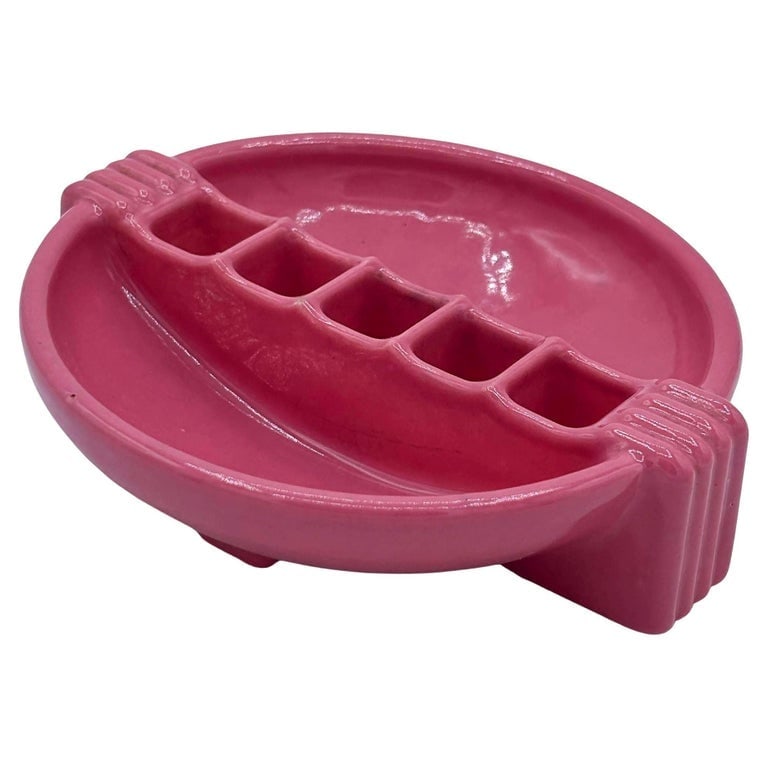 Streamline Art Deco Snuf A Rette Pink Ashtray by National Porcelain Co: Pink Art Deco "Snuff-a-Rette " Ashtray by National Porcelain Company in Trenton, New Jersey. The ashtray features a streamlined design with a ladder of cigarette holders in the center and speed lines