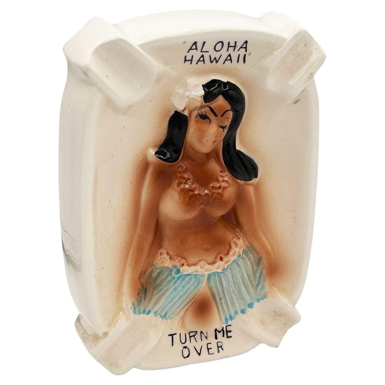 1950 Double Sided Ashtray Hawaiian "Turn Me Over" Cheeky Hula Girl Ashtray: Mid-century Era pink and green hula girl "Turn Me Over" ceramic ashtray. The ashtray features a beautifully detailed pink hula girl opening up her hula skirt to reveal a little leg with the text "Turn