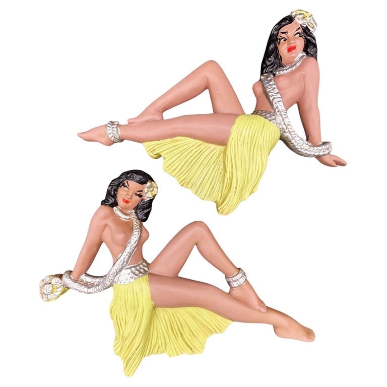 MCM Hawaiian Art Pottery Figure Pin-up Yellow Hula Girl Wall Sculpture, Pair: Original pair of California Art Pottery Figure Hawaiian Hula girl wall sculptures. Each sculpture features a beautiful girl sitting with a raised leg, a grass skirt, a flower lei, and Hibiscus in thei
